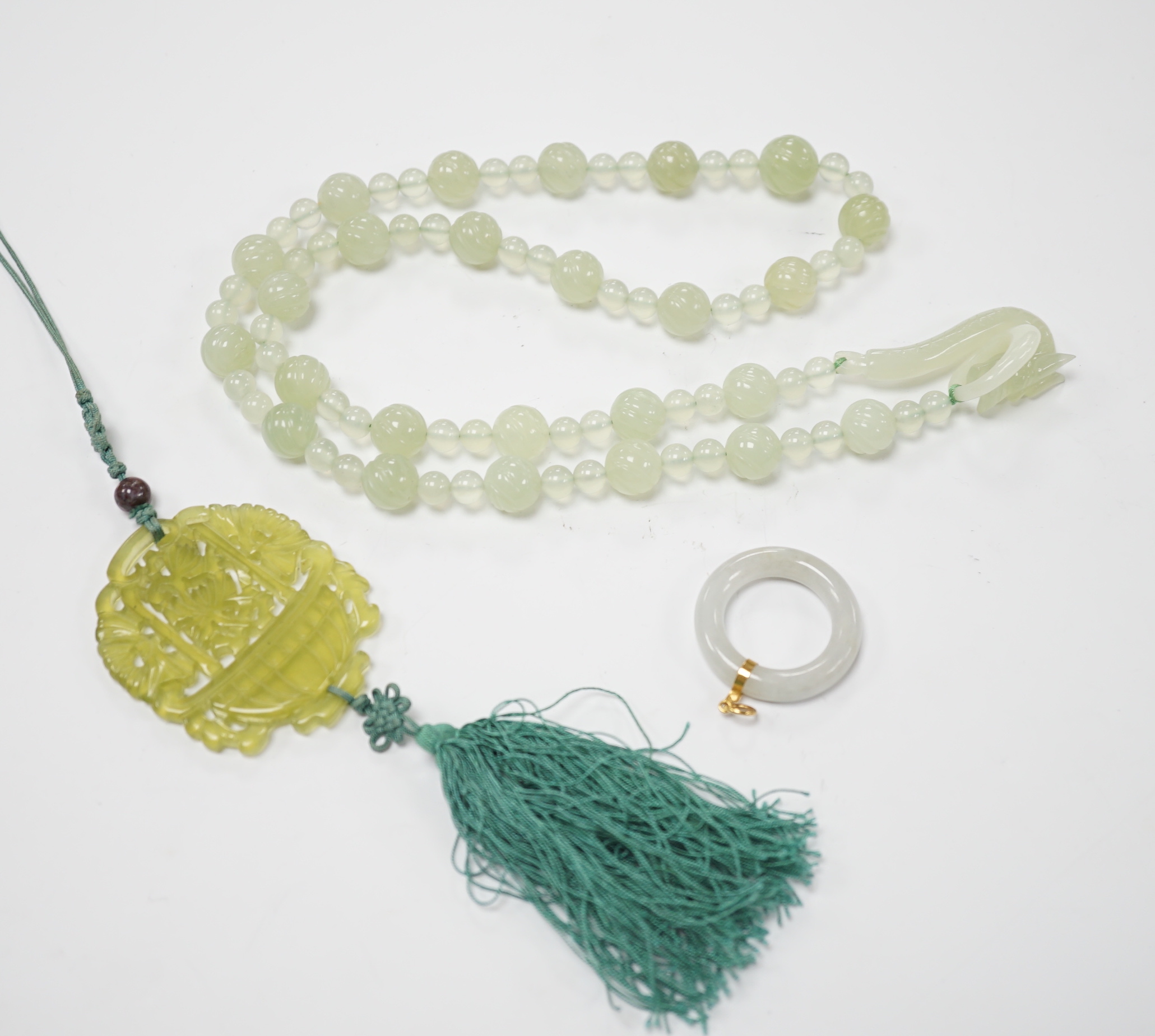 A bowenite jade bead necklace with dragon head clasp, circular pendant and carved disc                                                                                                                                      