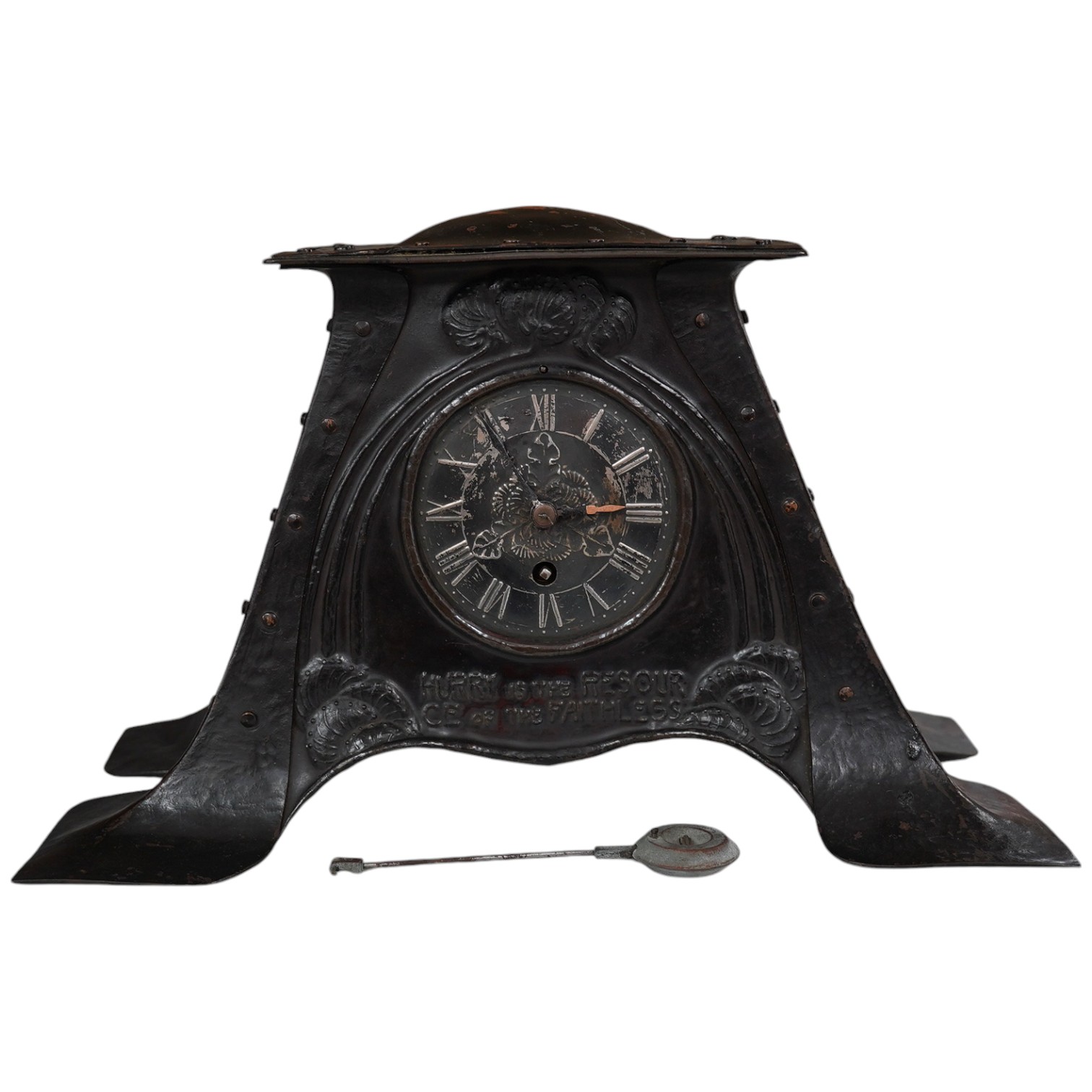 An Arts & Crafts embossed copper mantel timepiece, probably Glasgow School of Art, c.1900, with pewter dial, the text under the dial reads; ‘Hurry is the resource of the faithless’, 21.5cm high. Condition - fair, restora