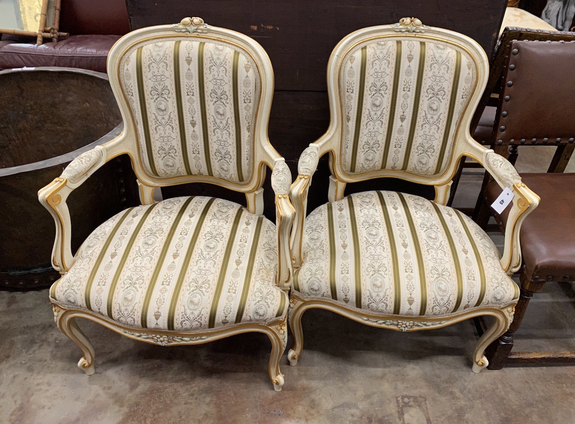 A pair of Louis VI style parcel gilt cream painted fauteuils, width 65cm, depth 52cm, height 92cm                                                                                                                           