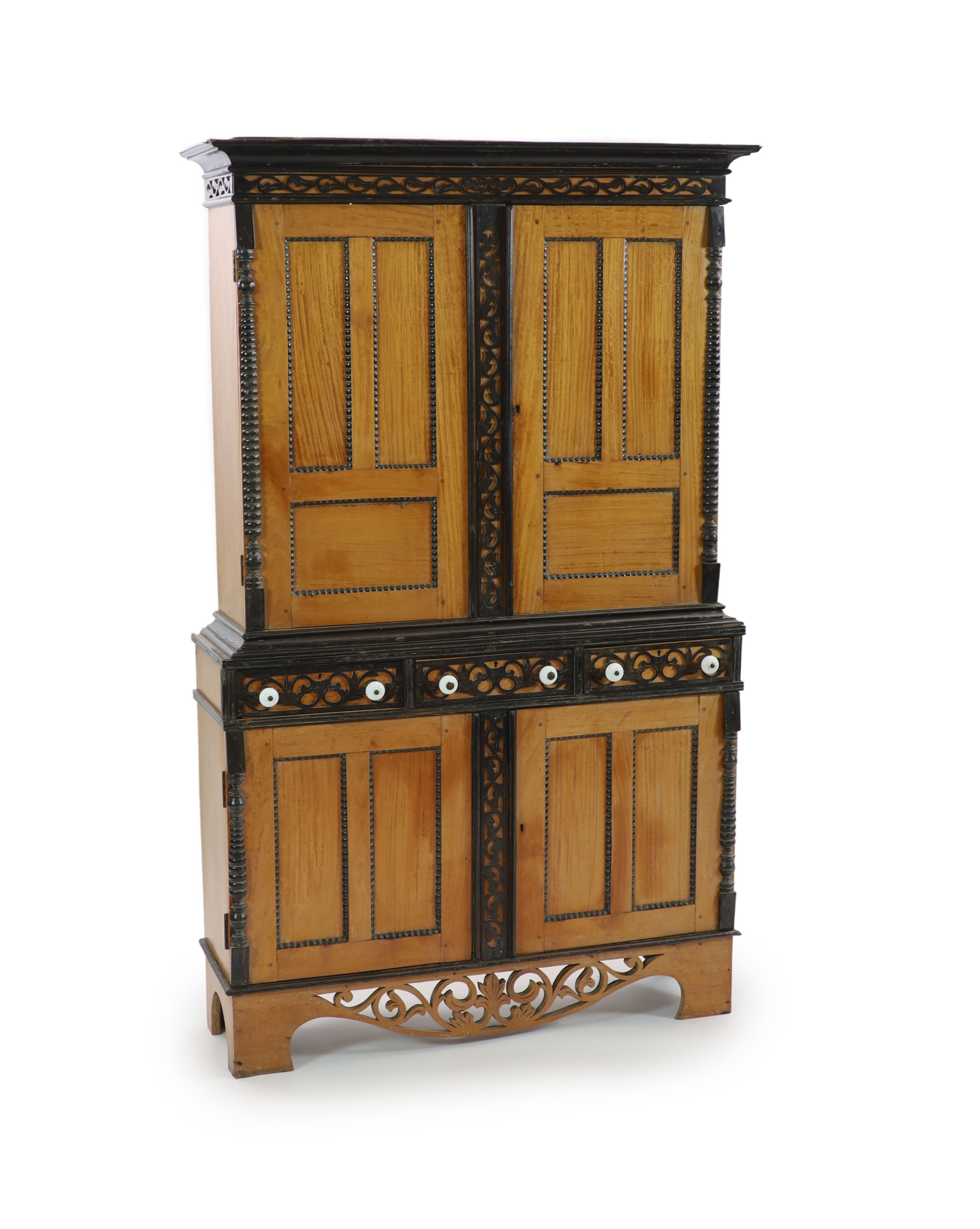 A mid 19th century Ceylonese satinwood and ebony side cabinet, H 194cm. W 120cm. D 37cm.                                                                                                                                    