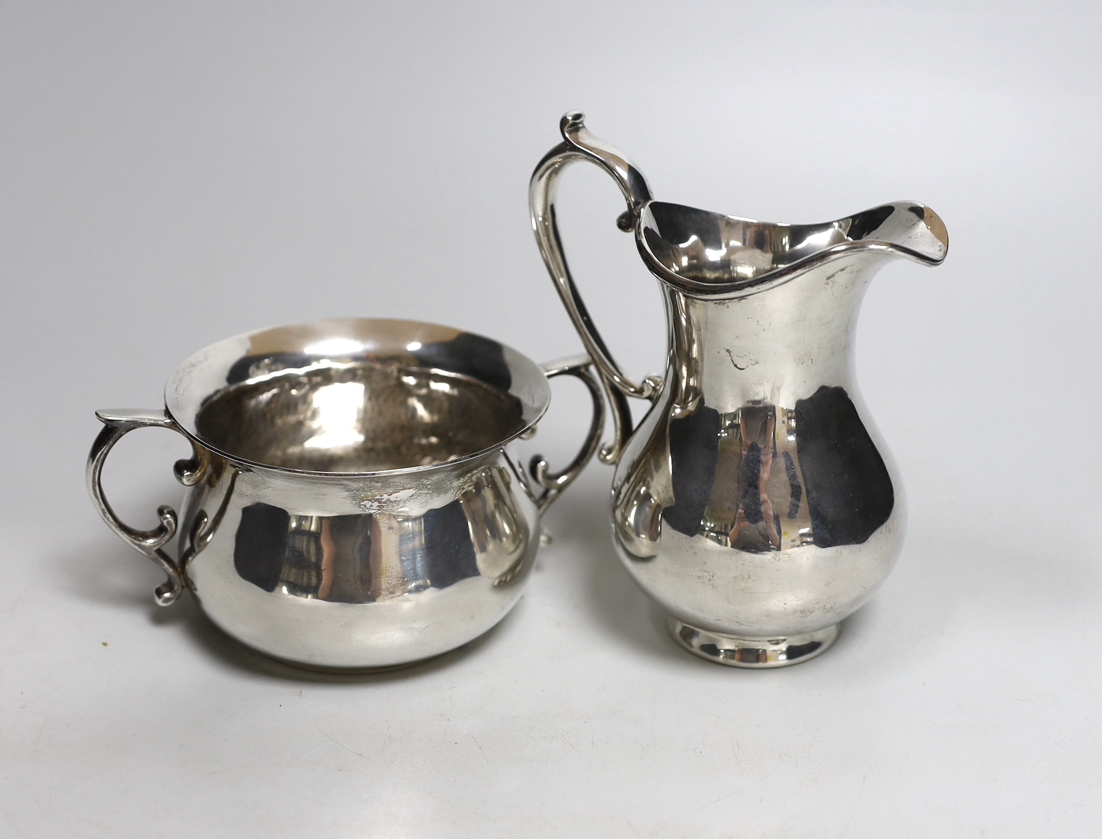 An Elizabeth II silver sugar bowl and a cream jug, by Rodney Clive Pettit, London, 1997, jug height 15cm, 20.2oz.                                                                                                           