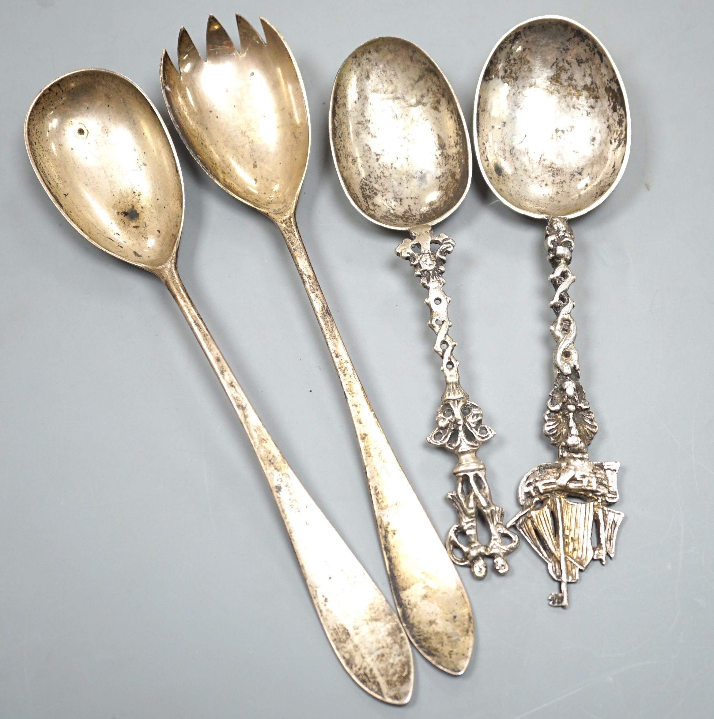 A pair of Edwardian silver salad servers, by Charles & George Asprey, London, 1906, 21.5cm, 113 grams and two continental white metal spoons.                                                                               