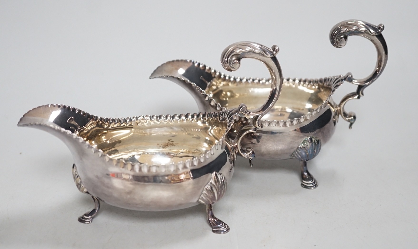 A pair of early George III silver sauceboats, with flying scroll handles, maker, CH, London, 1768, length 15.5cm, 10.4oz.                                                                                                   