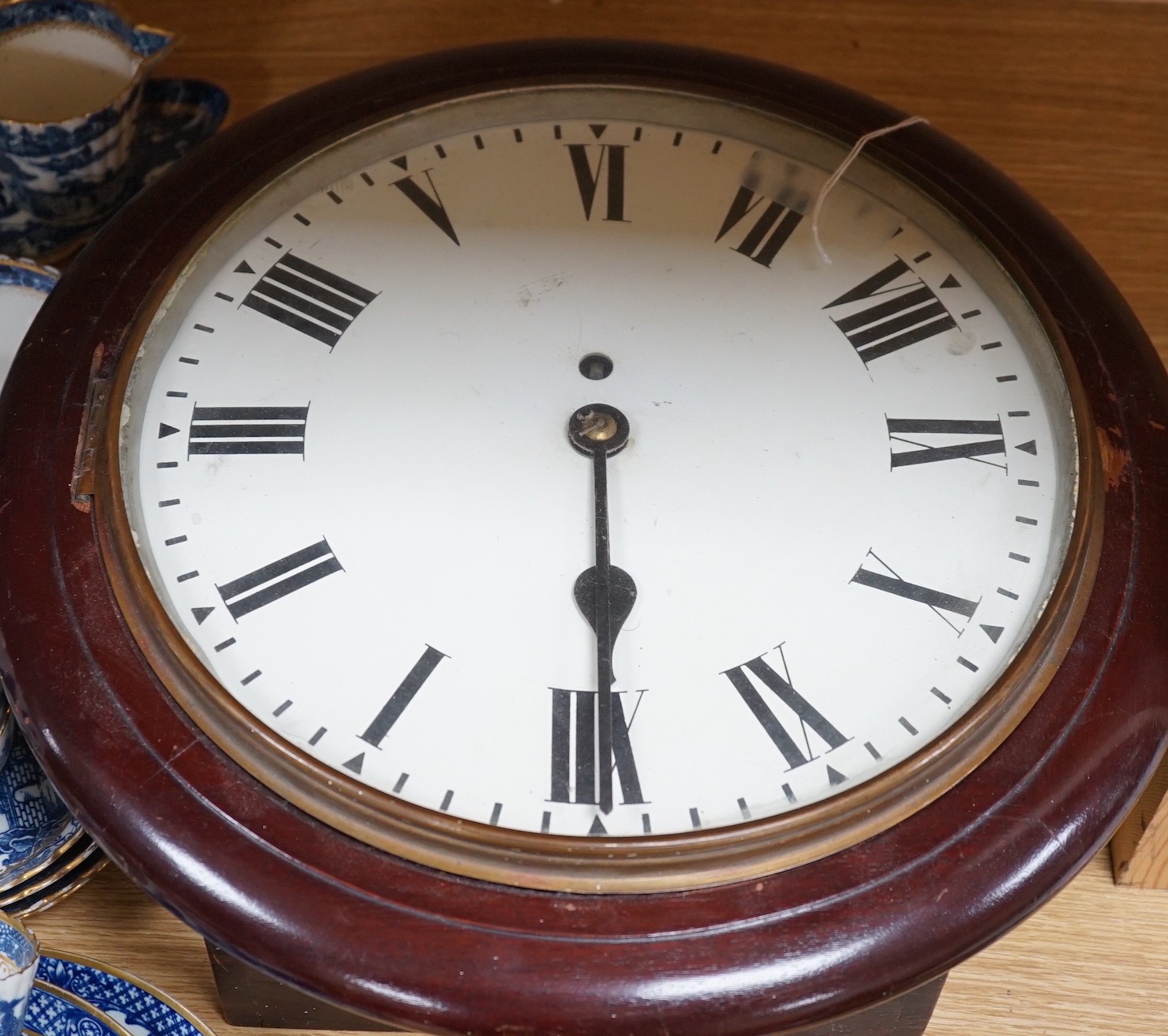 An early 20th century mahogany circular wall clock, single fusee movement, 41cms wide                                                                                                                                       