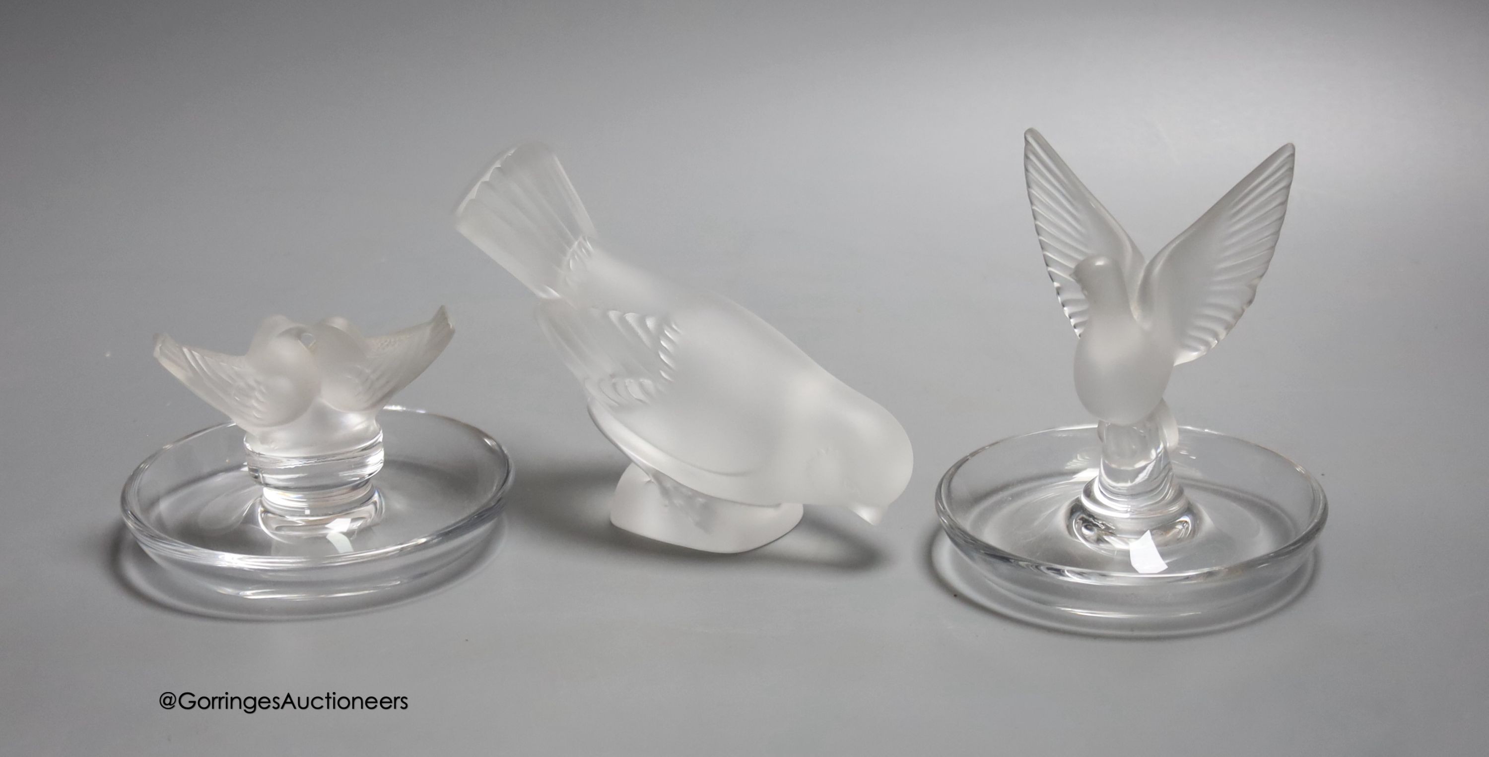Two Lalique ashtrays mounted with birds, etched signatures to bases, and a Lalique style frosted glass bird paperweight                                                                                                     