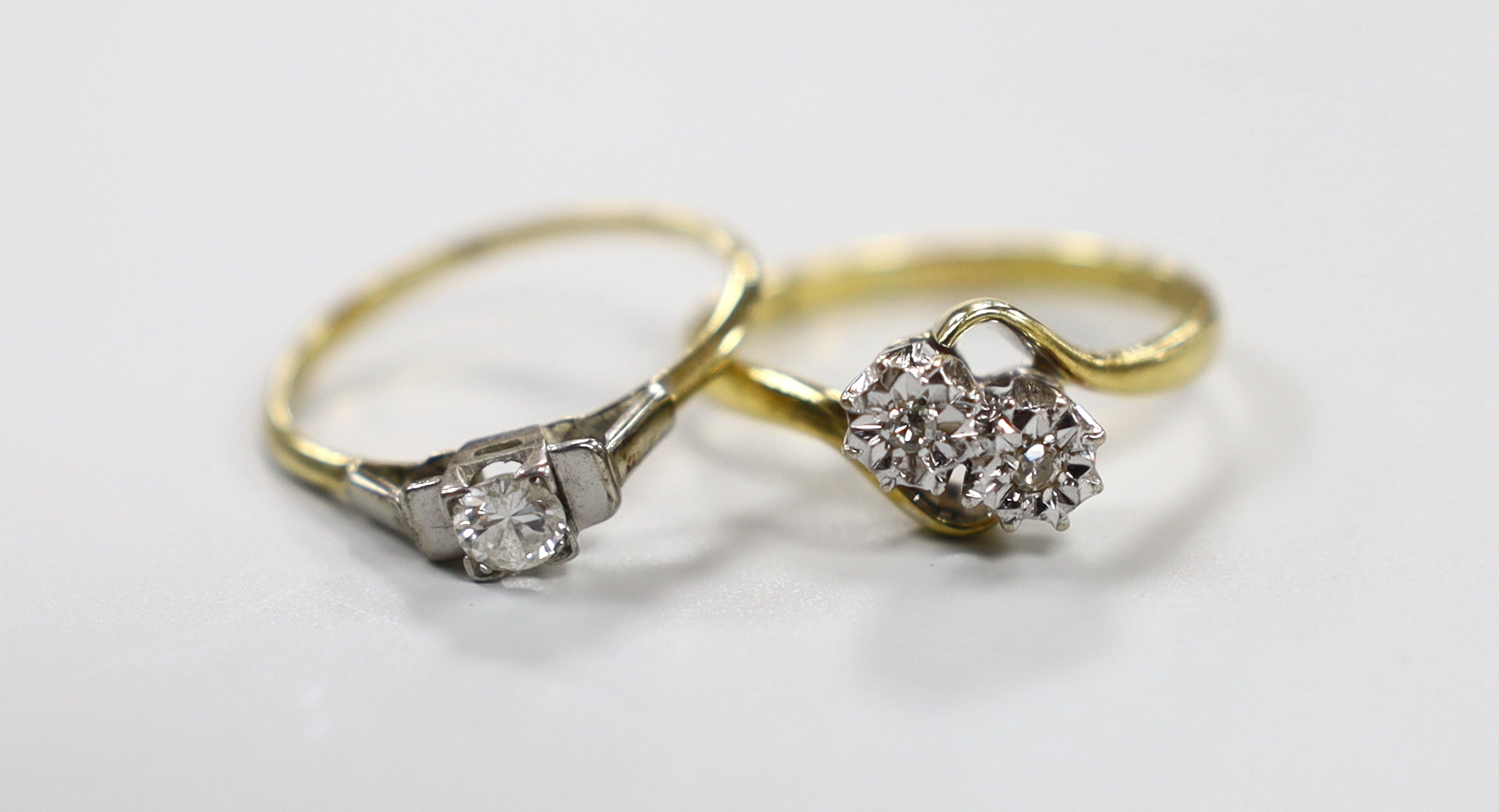 A gold and solitaire diamond ring, size N/O and a modern 18ct gold and illusion set two stone diamond crossover ring, gross weight 4.9 grams.                                                                               