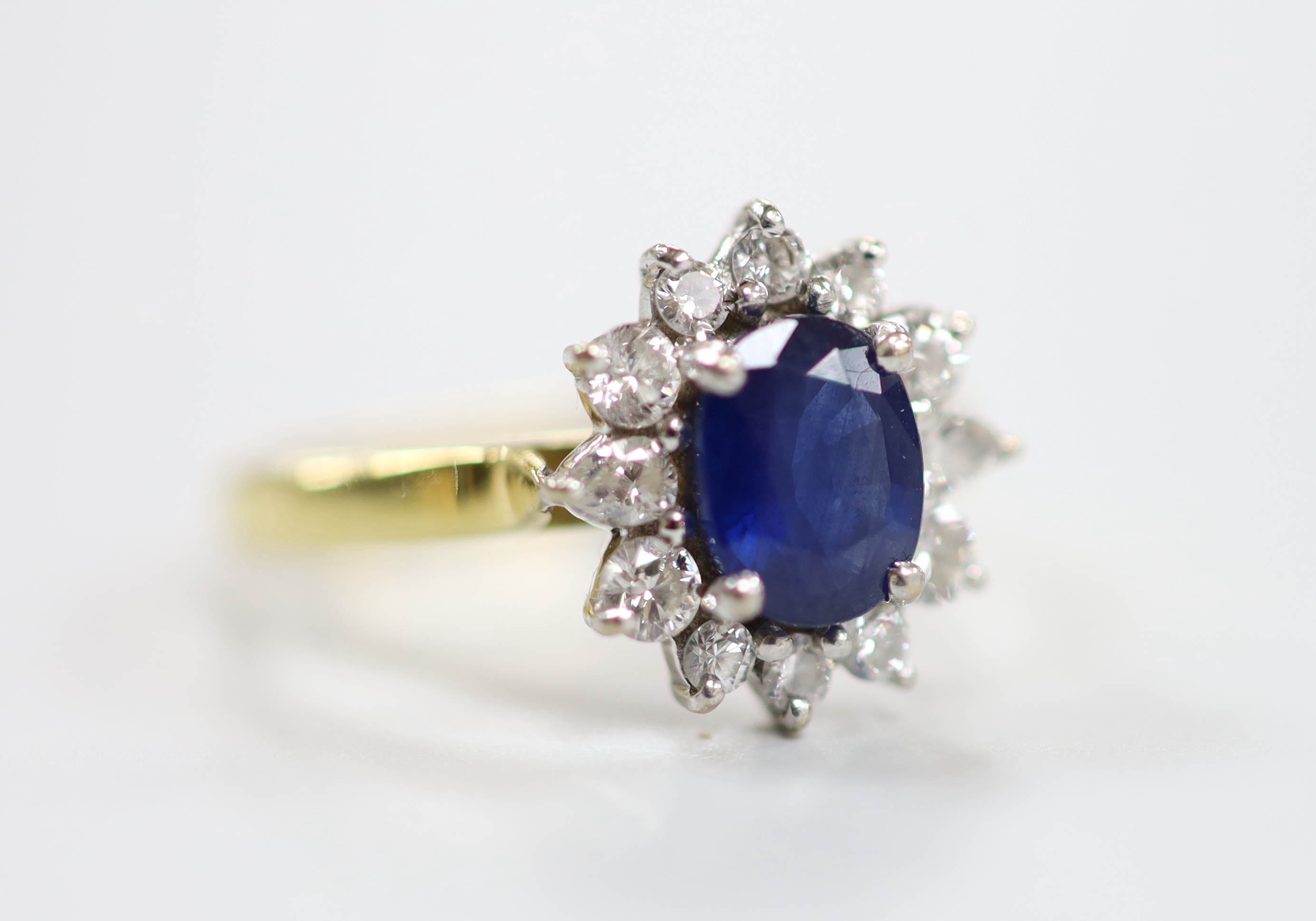 A modern 18ct gold sapphire and diamond set oval cluster ring, size J, gross weight 3.2 grams.                                                                                                                              