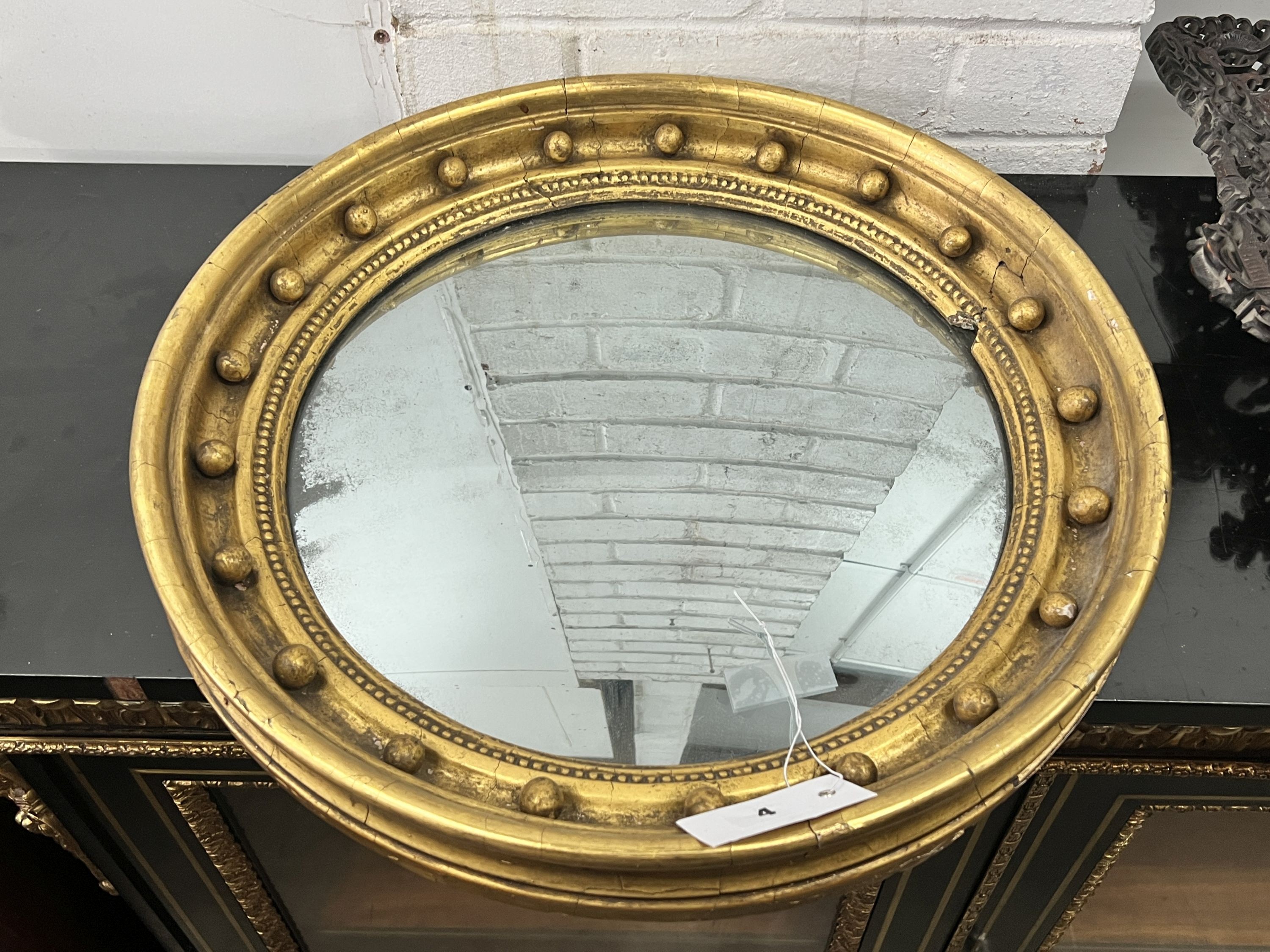 A Regency mahogany circular gilt framed convex wall mirror, diameter 49cm                                                                                                                                                   