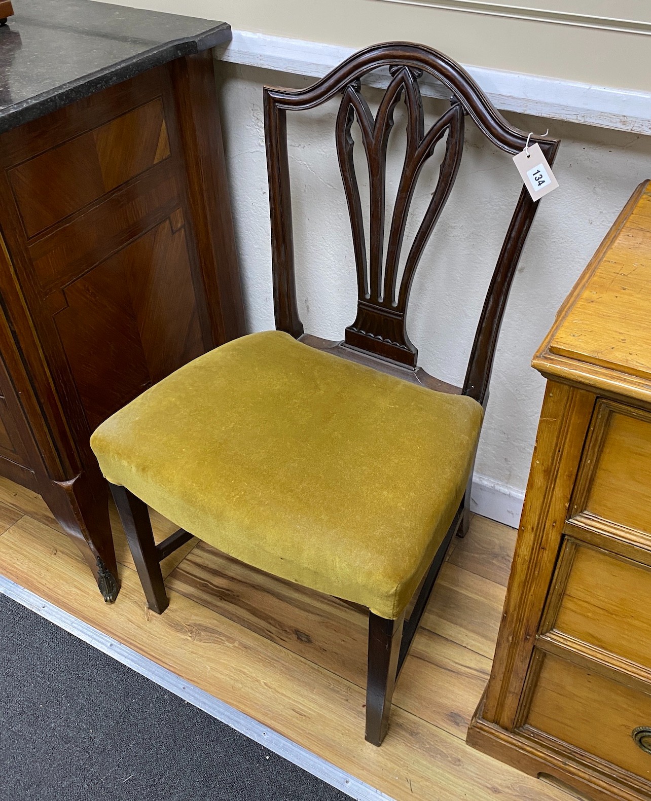 A pair of George III Hepplewhite style mahogany dining chairs, with stuff-over seats, on square tapering legs                                                                                                               