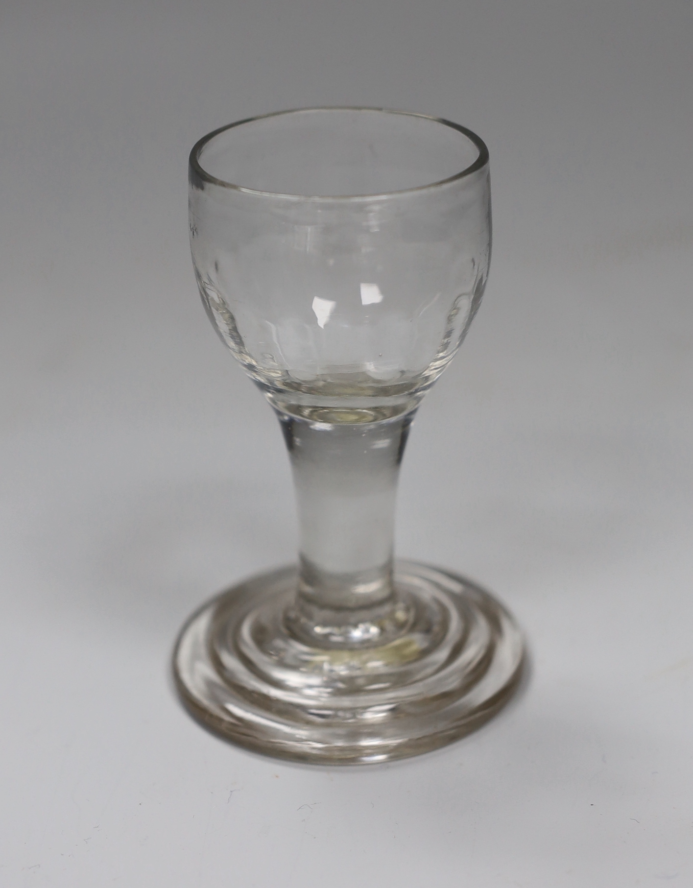A George II cordial glass, half-moulded bowl and terraced foot, 10cm tall                                                                                                                                                   
