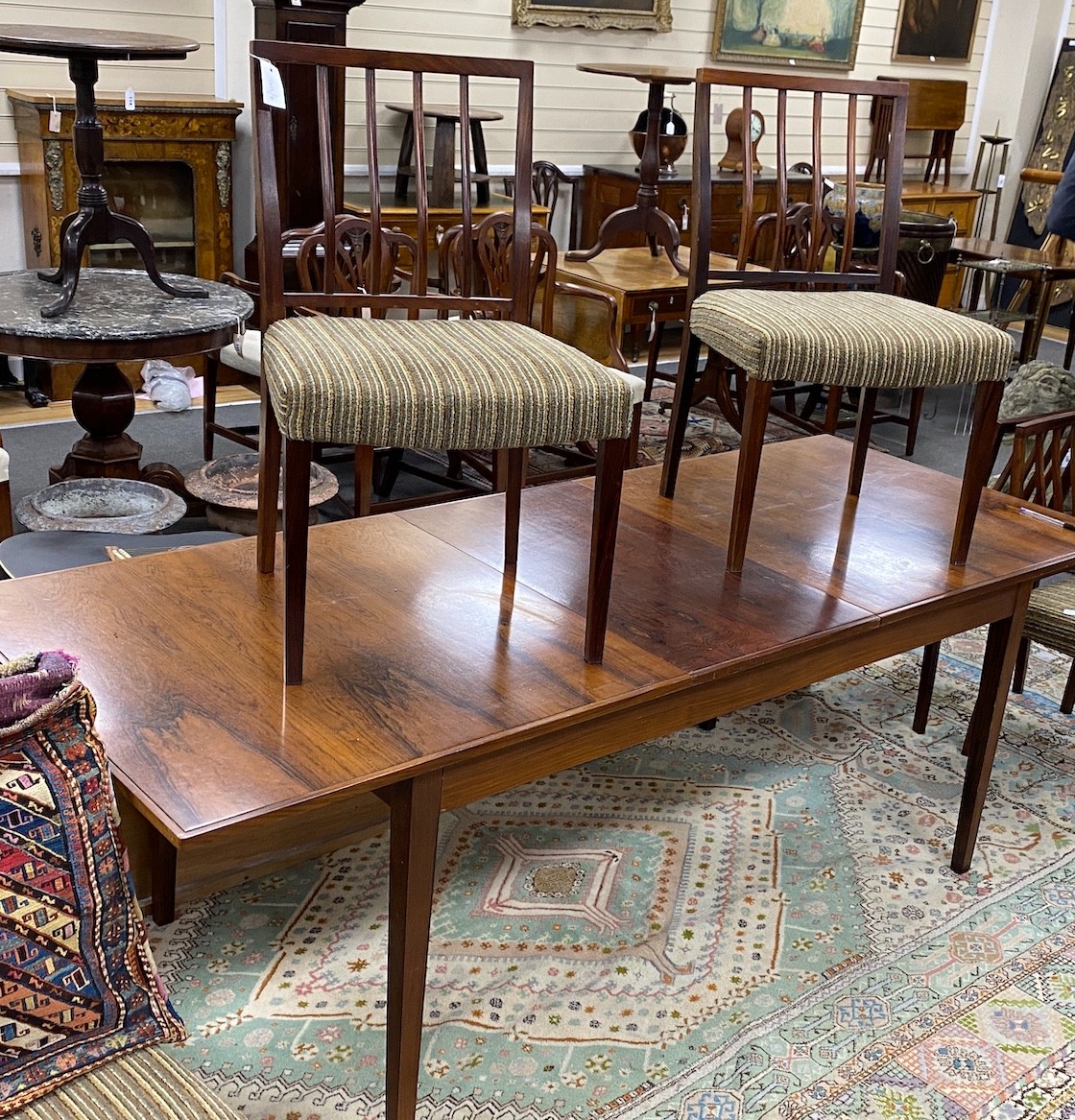 A mid century rosewood extending dining table, length 214cm extended, width 84cm, height 72cm six chairs and wall hanging side cabinet                                                                                      