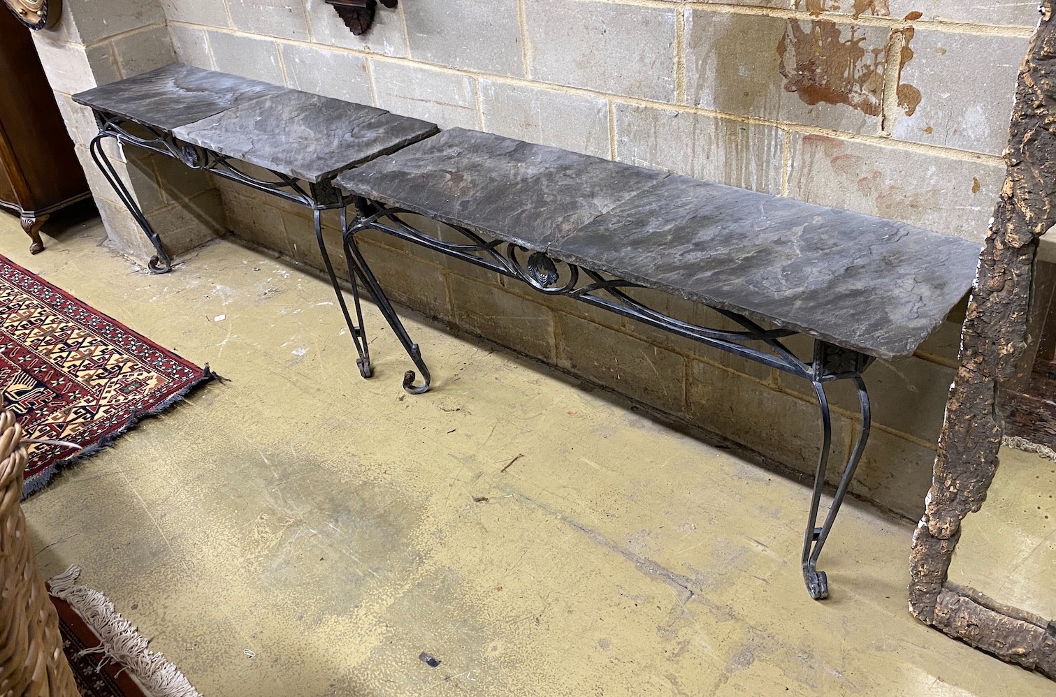 A pair of wrought iron slate top console tables, width 146cm, depth 45cm, height 75cm                                                                                                                                       