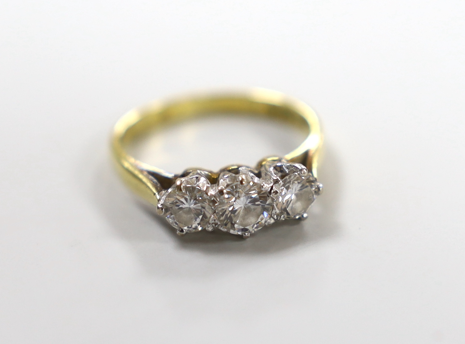 A modern 18ct gold and three stone diamond set ring, size I, gross weight 2.9 grams.                                                                                                                                        