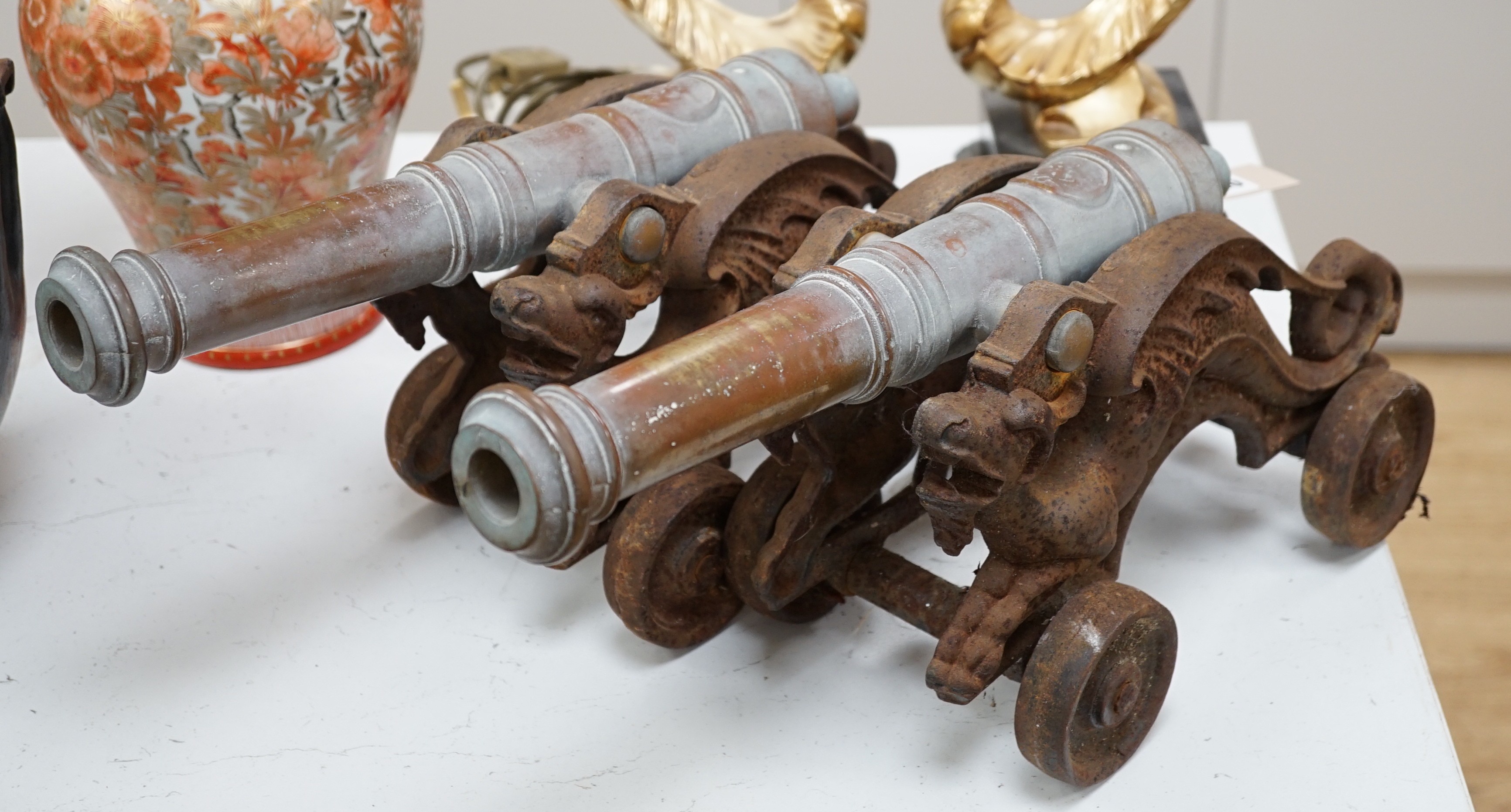 A pair of brass and cast iron model cannons. 45cm wide                                                                                                                                                                      