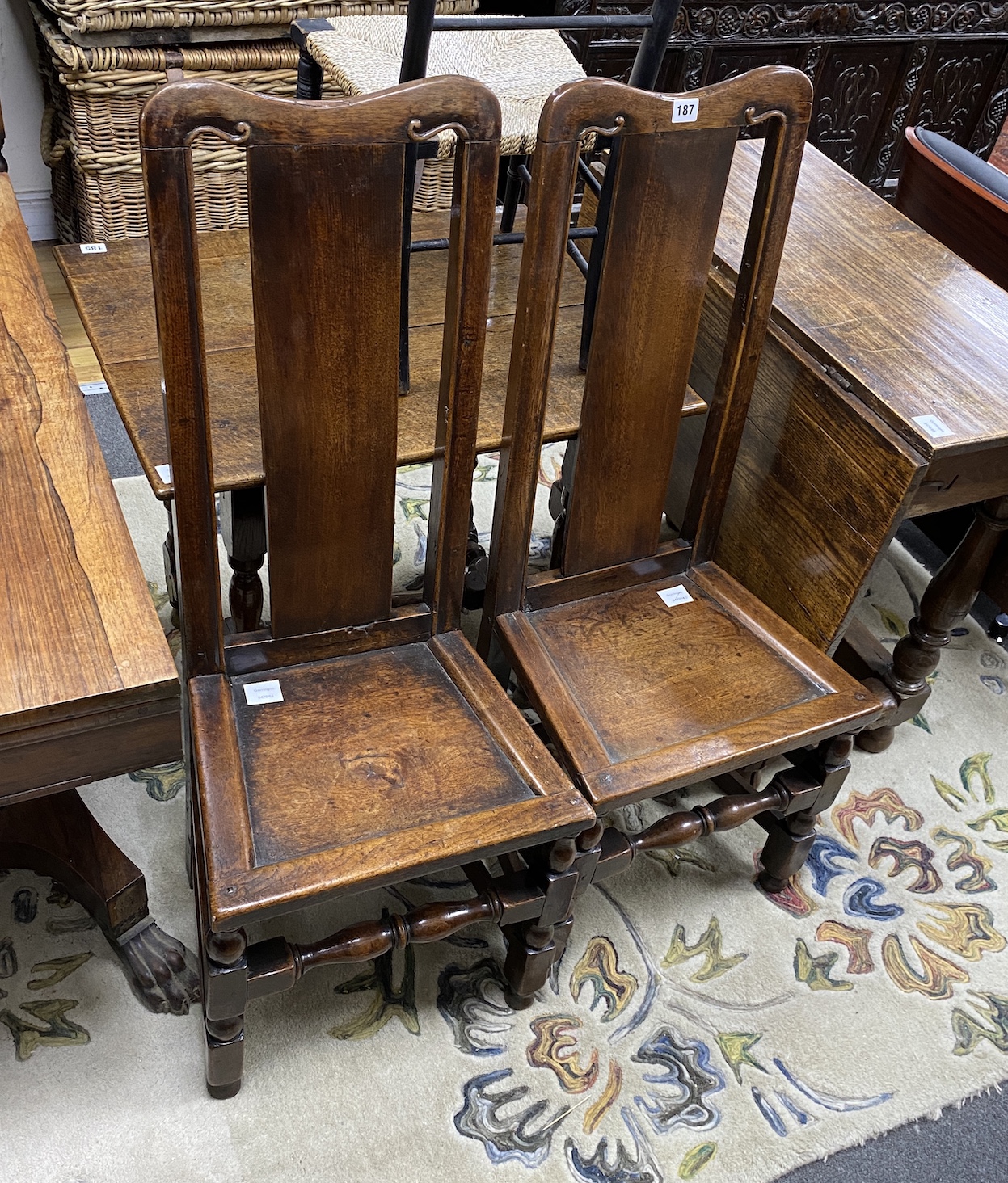 A pair of William and Mary oak chairs, c.1690, the solid splats and seats on turned legs, joined by stretchers, height 104cm                                                                                                
