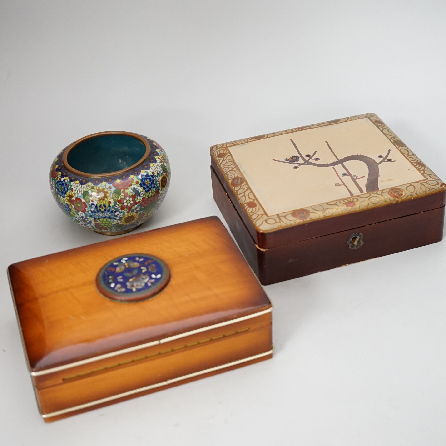 A group of Japanese lacquer boxes and two cloisonné enamel vases and a polished fossil                                                                                                                                      