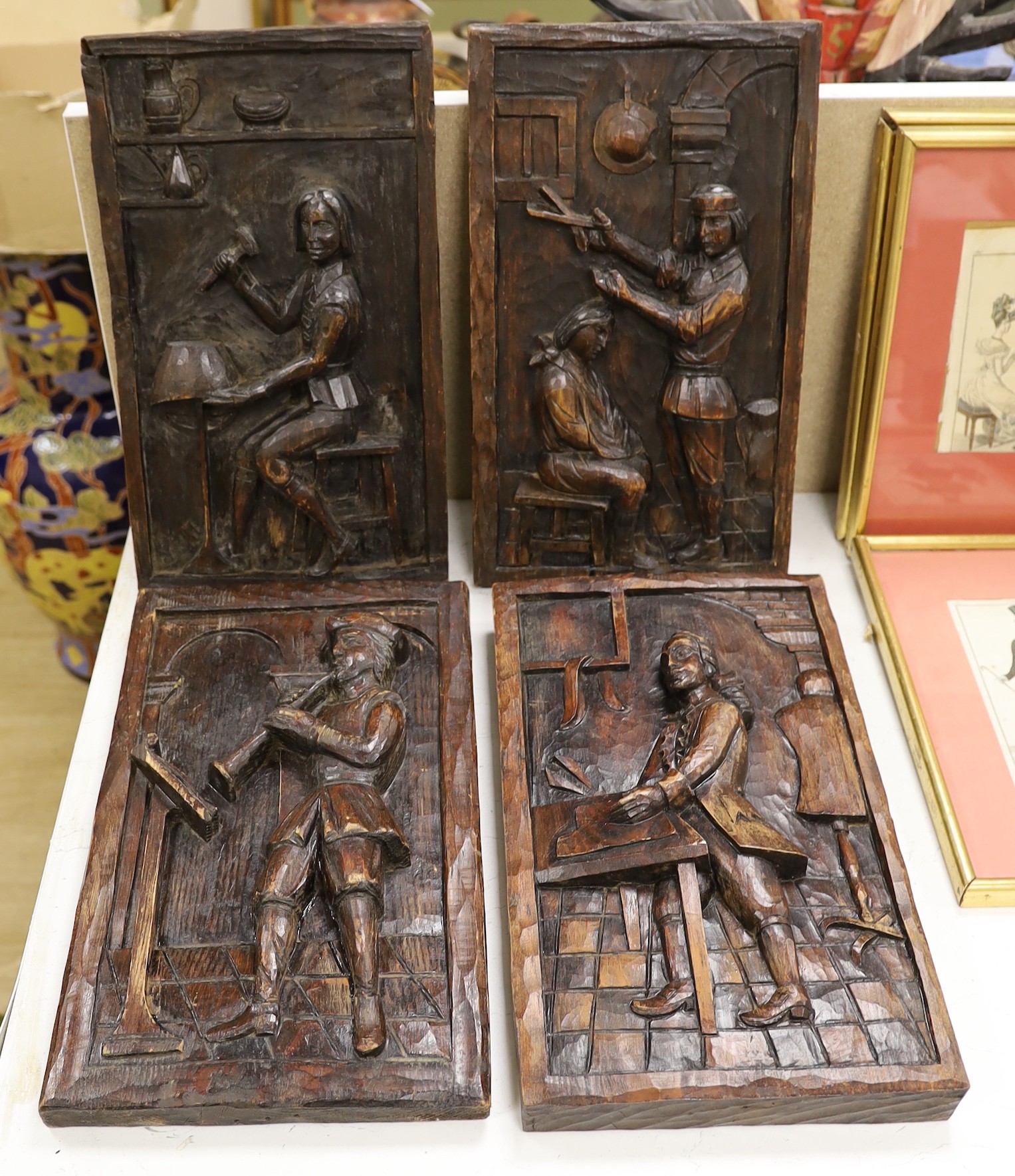 A set of four carved and stained pine figurative panels, 39cms high x 23cms wide                                                                                                                                            