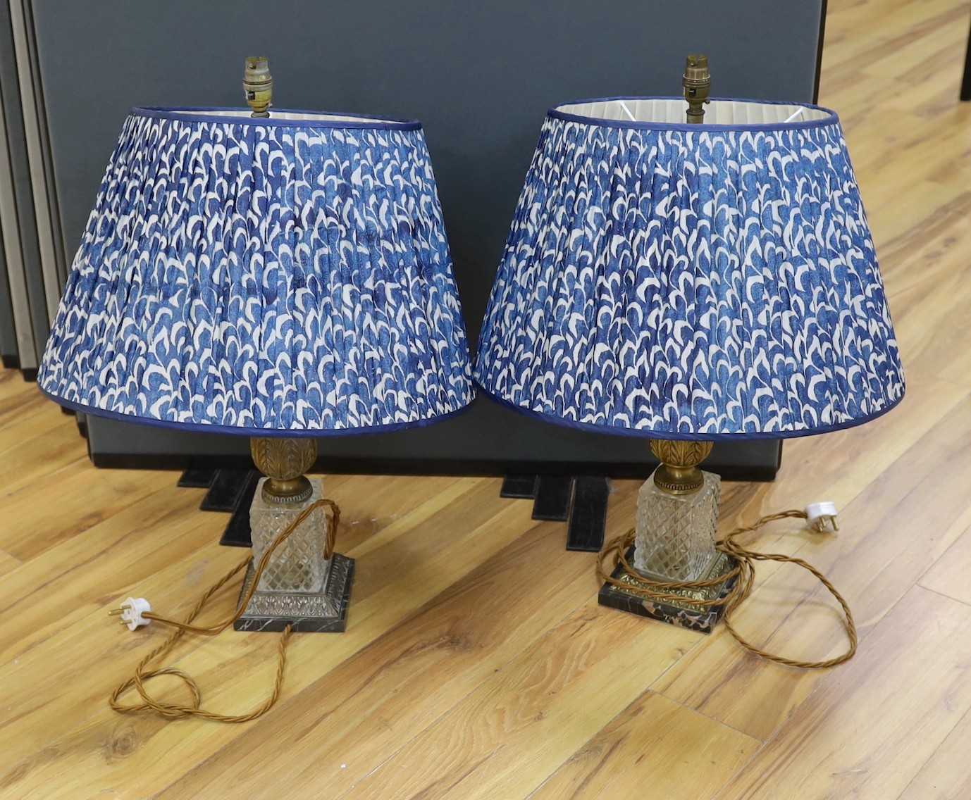 A pair of gilt brass and glass lamps with shades, 71cms high including light fitting                                                                                                                                        
