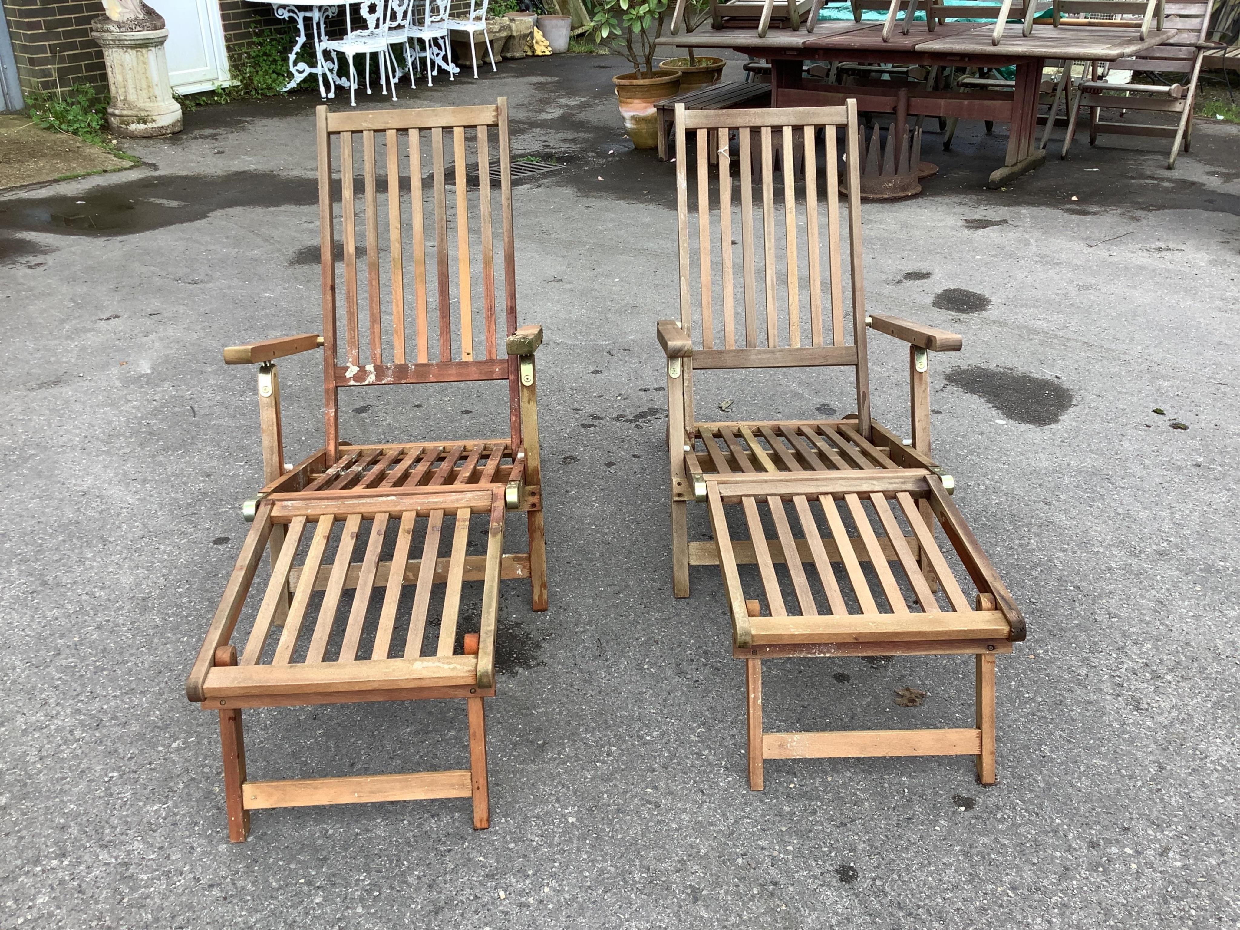 A pair of John Lewis brass mounted folding teak steamer garden chairs with seat cushions                                                                                                                                    