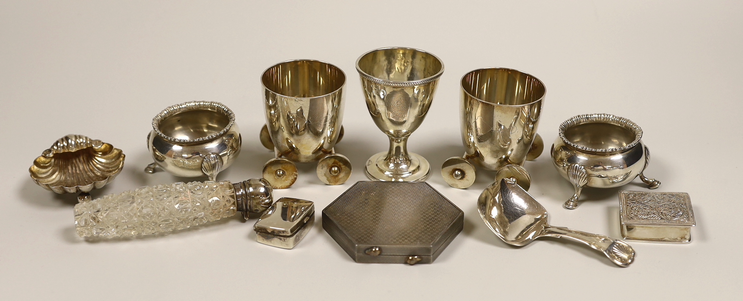 A George IV silver egg cup, London, 1821, 65mm, eight other small silver items including a pair of bun salts, 19th century caddy spoon, shell salt, compact, two pill boxes and a mounted glass scent bottle and two plated 