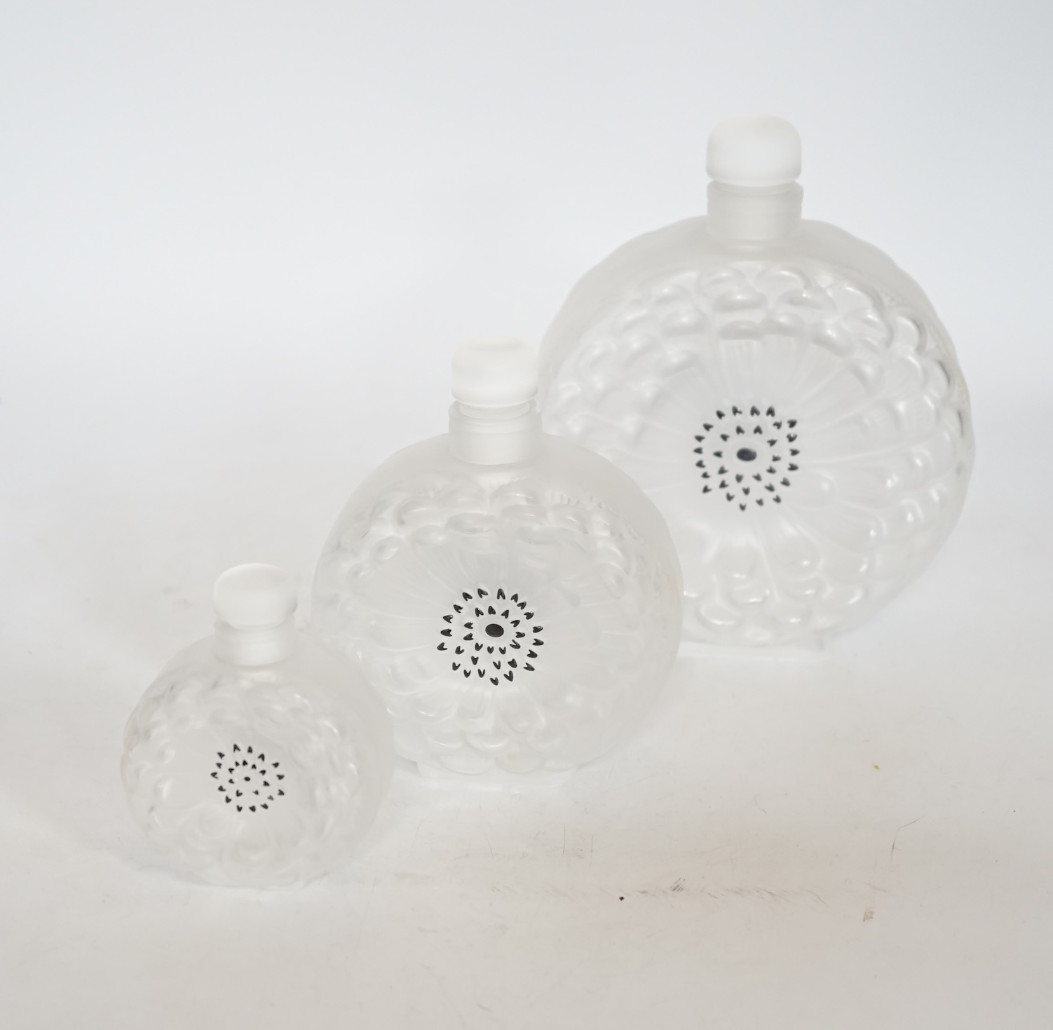 Three graduated Lalique Dahlia pattern glass scent bottles and stoppers, signed to the bases, largest 18cm high                                                                                                             