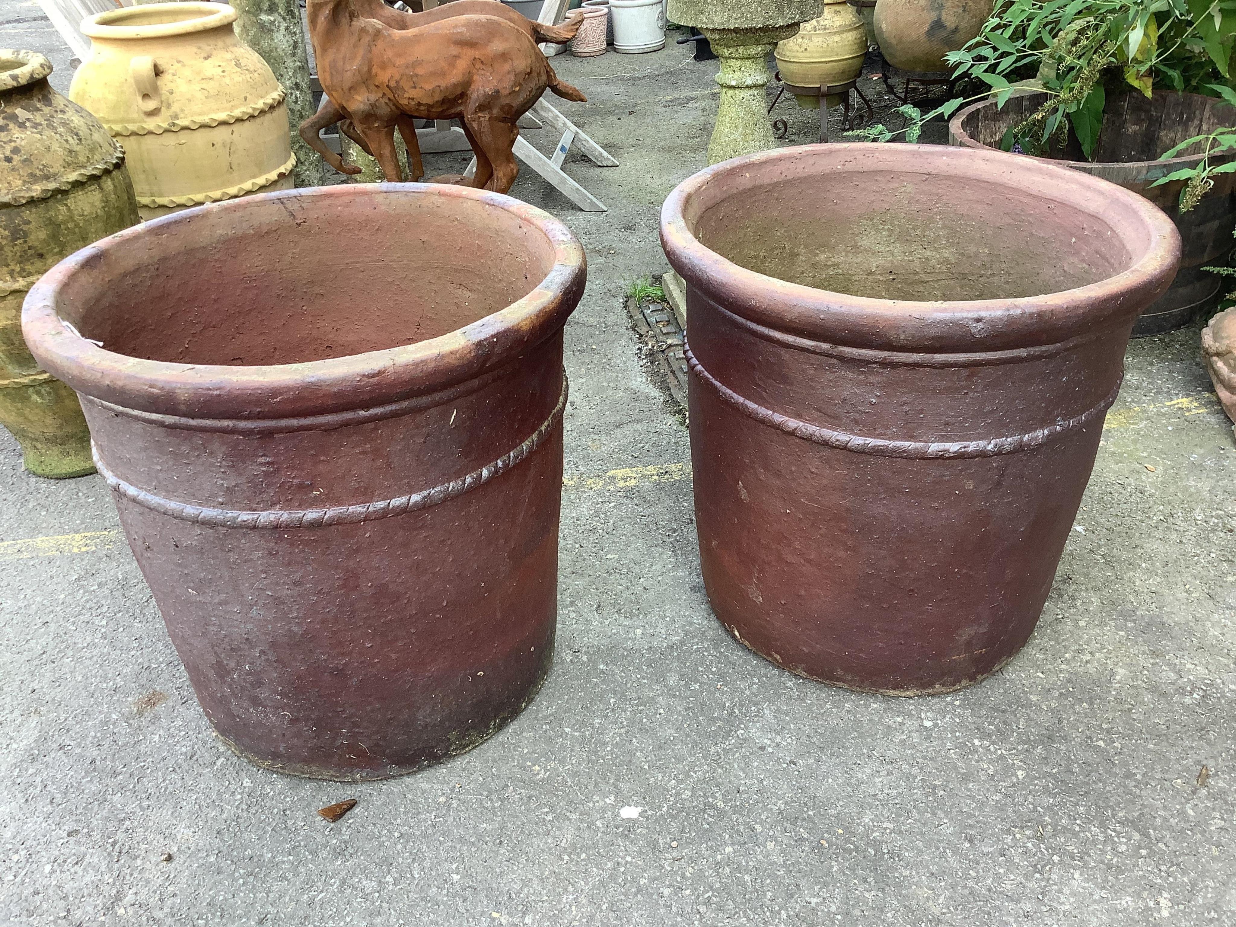 A large pair of brown glazed pottery garden urns, diameter 58cm, height 57cm. Condition - weathered, otherwise good                                                                                                         