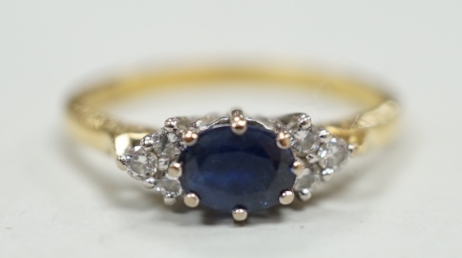 A modern 18ct gold, single stone sapphire and six stone diamond chip set ring, size O/P, gross weight 3.1 grams.                                                                                                            