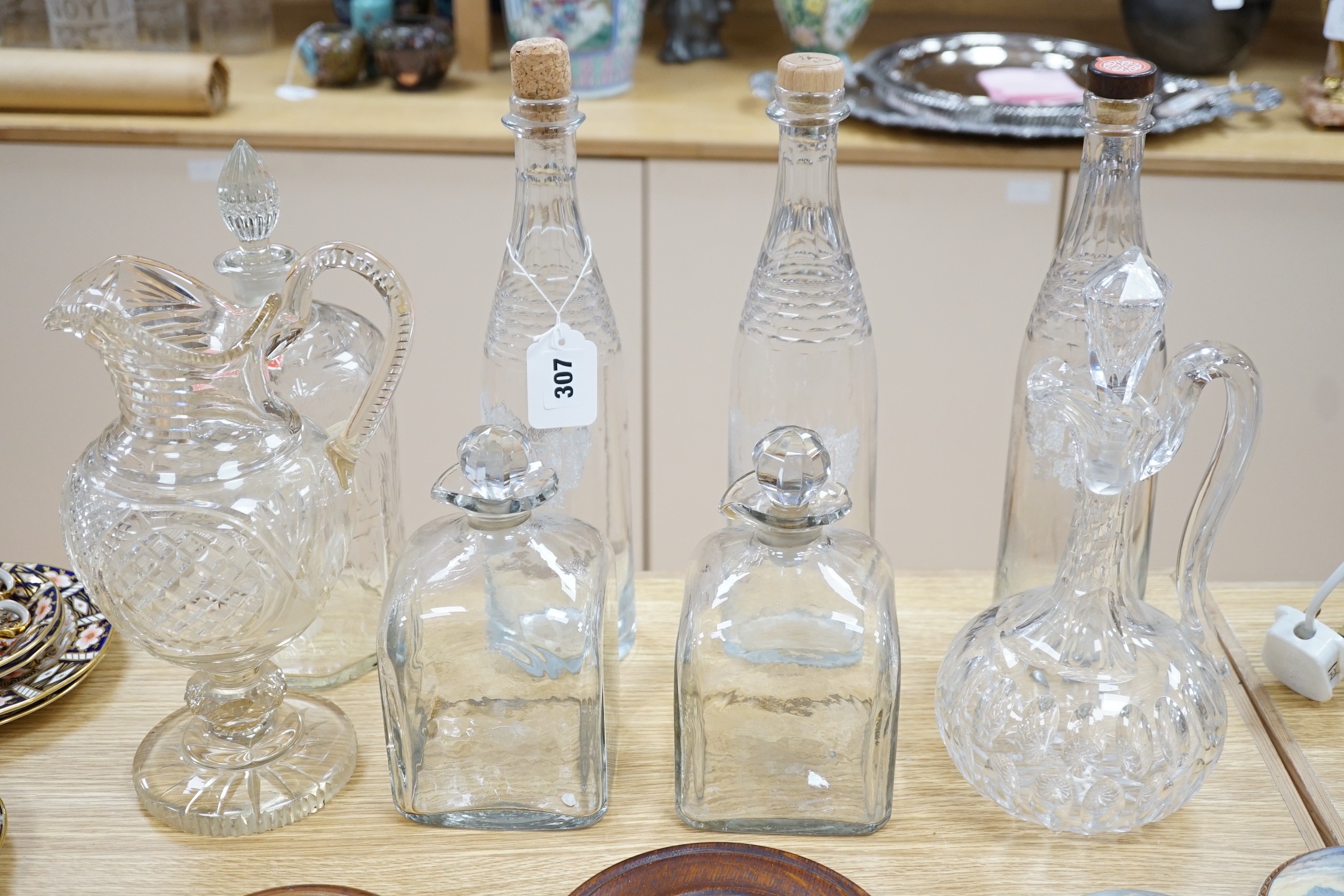 A Victorian cut glass Claret jug and stopper, a step cut pedestal jug, a pair of Dutch decanters, a large Dutch decanter and a set of three etched glass decanters named Kirsch, Cognac & Rhum                              