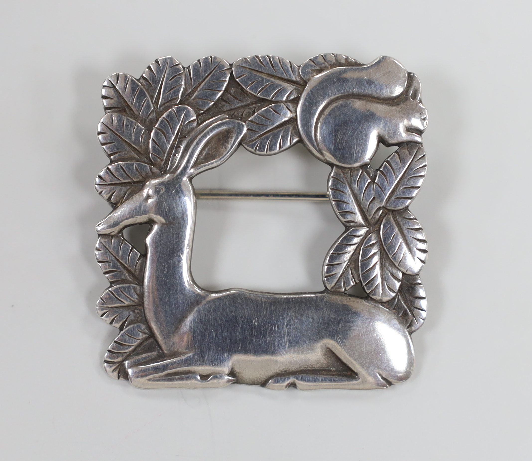 A Georg Jensen sterling recumbent deer and squirrel amongst foliage square brooch, design no. 318, 37mm.                                                                                                                    