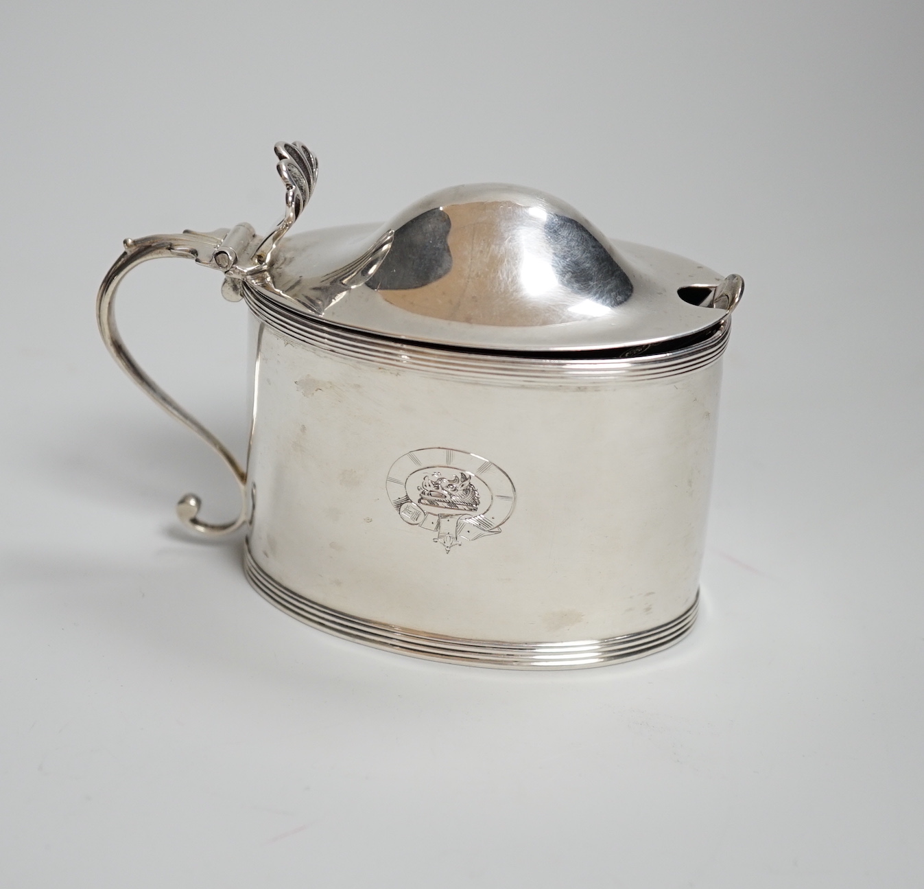 A George III oval silver drum mustard, with domed lid, blue glass liner and associated plated spoon, makers Peter, Anne and William Bateman, London 1799, 110 grams                                                         