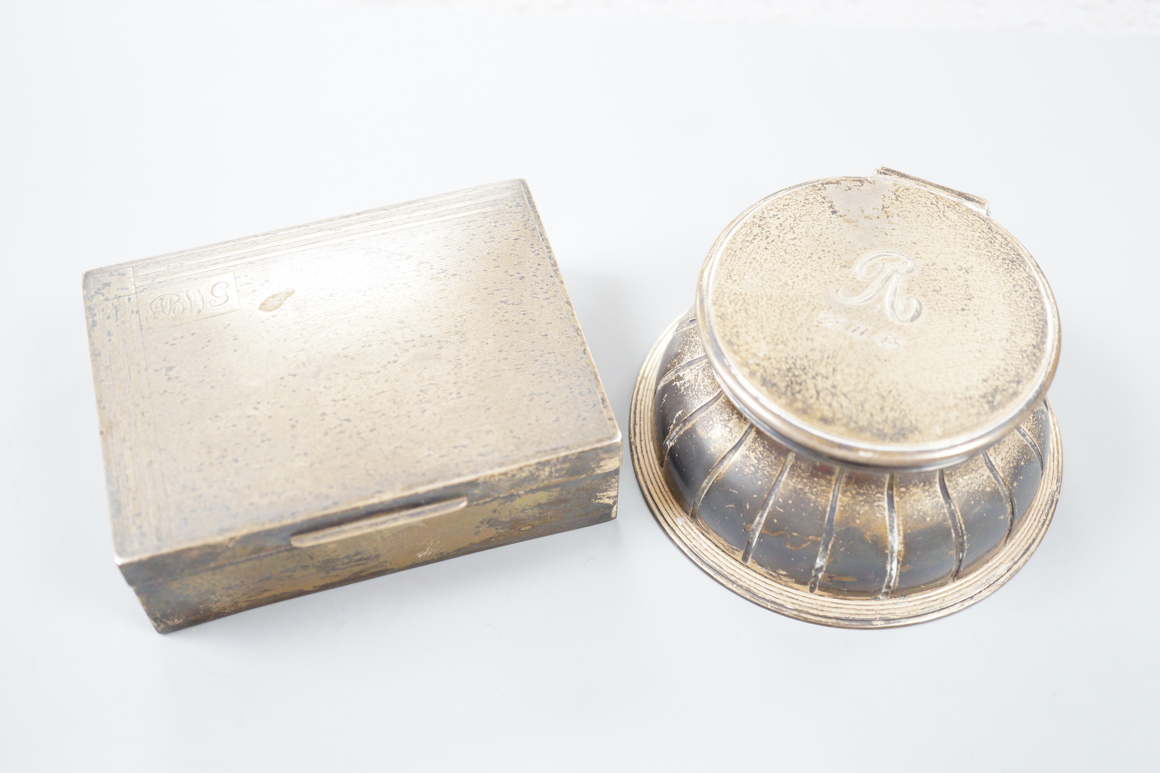 An Edwardian silver mounted circular glass inkwell by George Fox, London, 1901, diameter 11.3cm and a later silver mounted cigarette box.                                                                                   