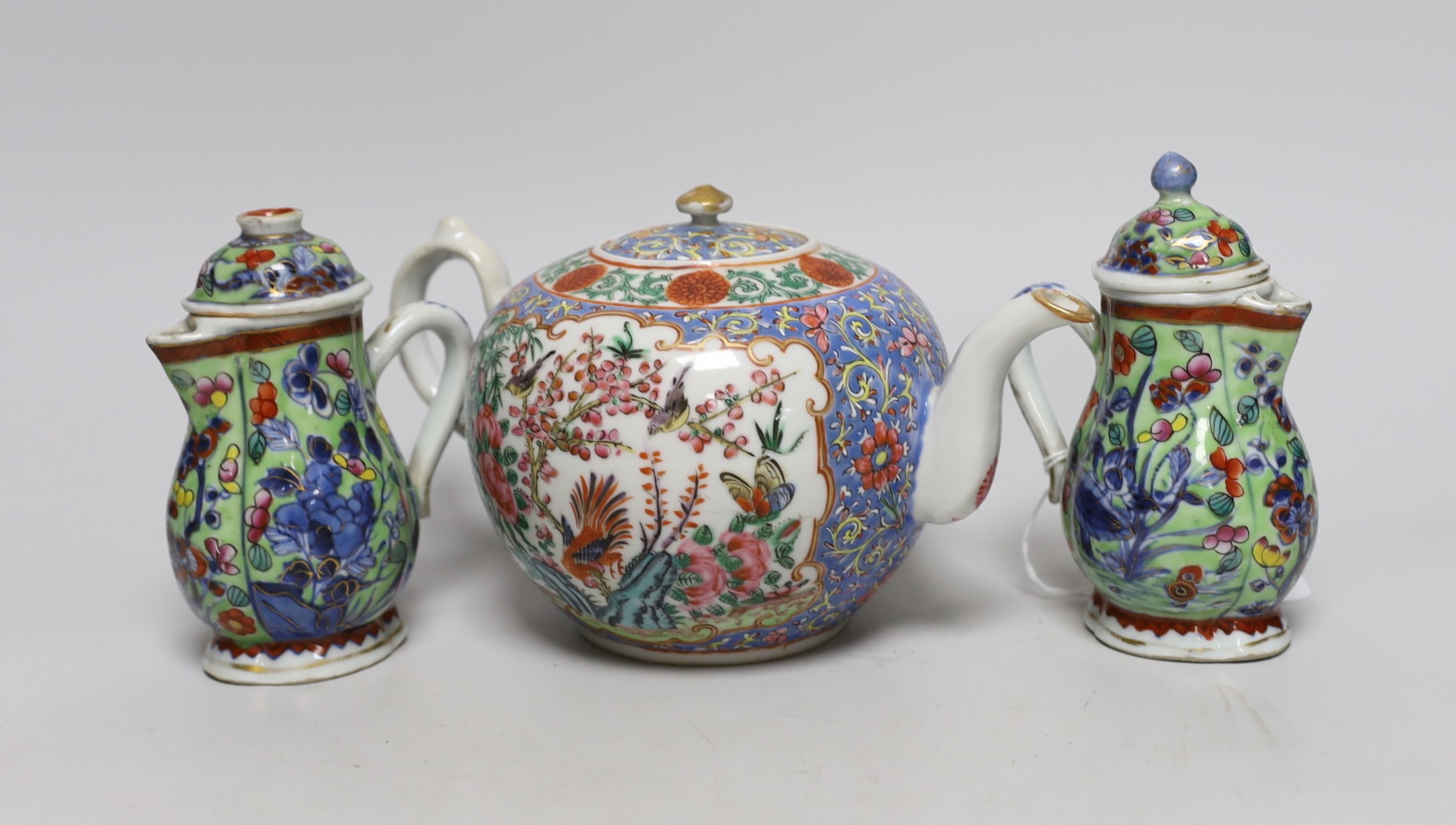 Two Chinese Kangxi clobbered jugs and covers, and a 19th century famille rose teapot, 13cms high                                                                                                                            