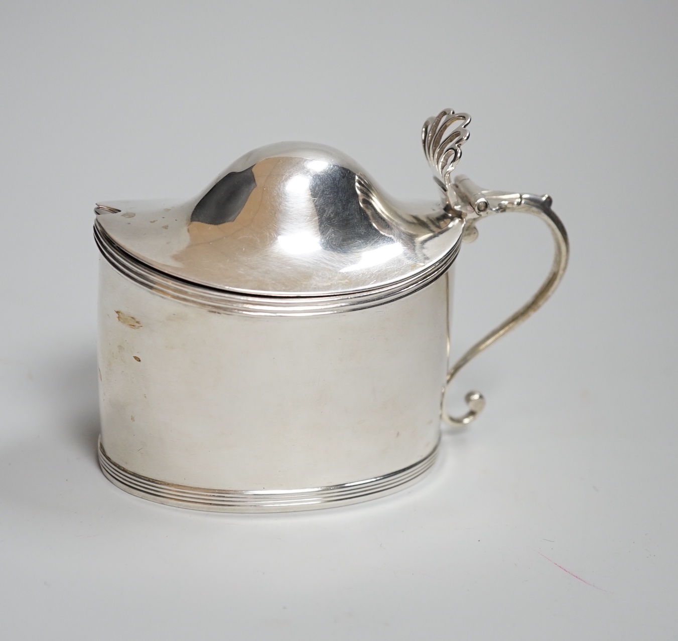 A George III oval silver drum mustard, with domed cover, glass liner and plated spoon, makers Peter, Anne and William Bateman, London 1800, 121 grams                                                                       