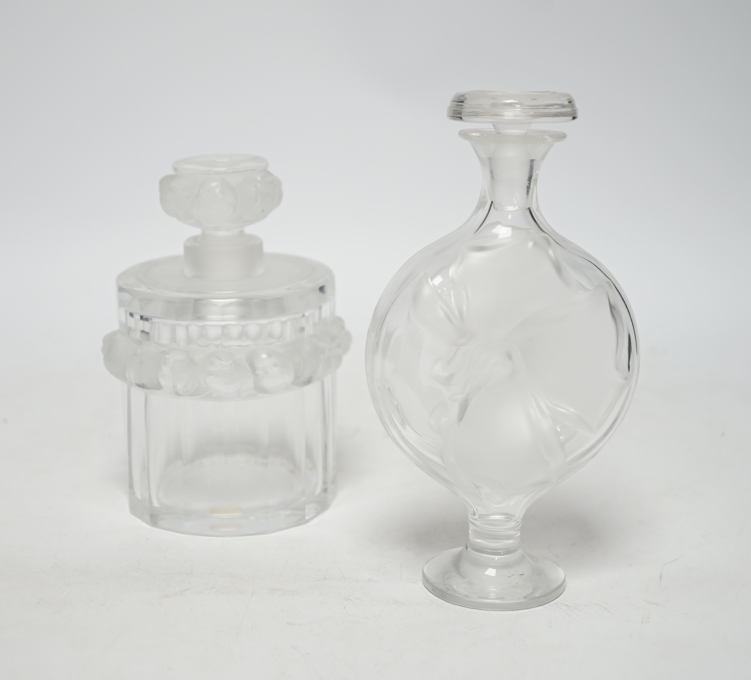 Two Lalique glass scent bottles and stoppers comprising ‘Robinson’ and ‘Moulin Rouge’, signed to the bases, largest 17cm high                                                                                               