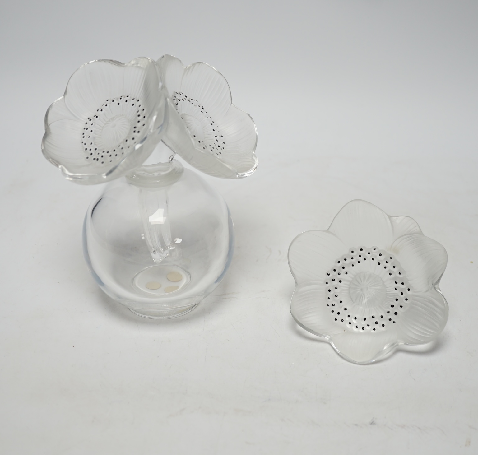 A Lalique anemone glass scent bottle and stopper, signed to the base, together with an associated anemone stopper, 16cm high                                                                                                