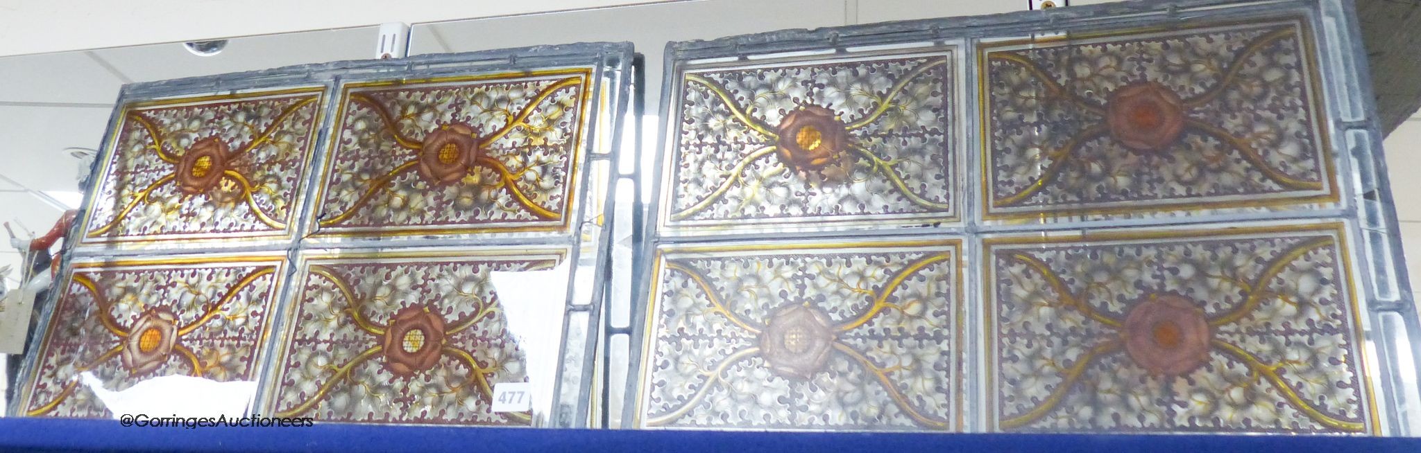 A pair of stained glass panels designed with oak leaves and Tudor roses, width 56cm height 38cm                                                                                                                             