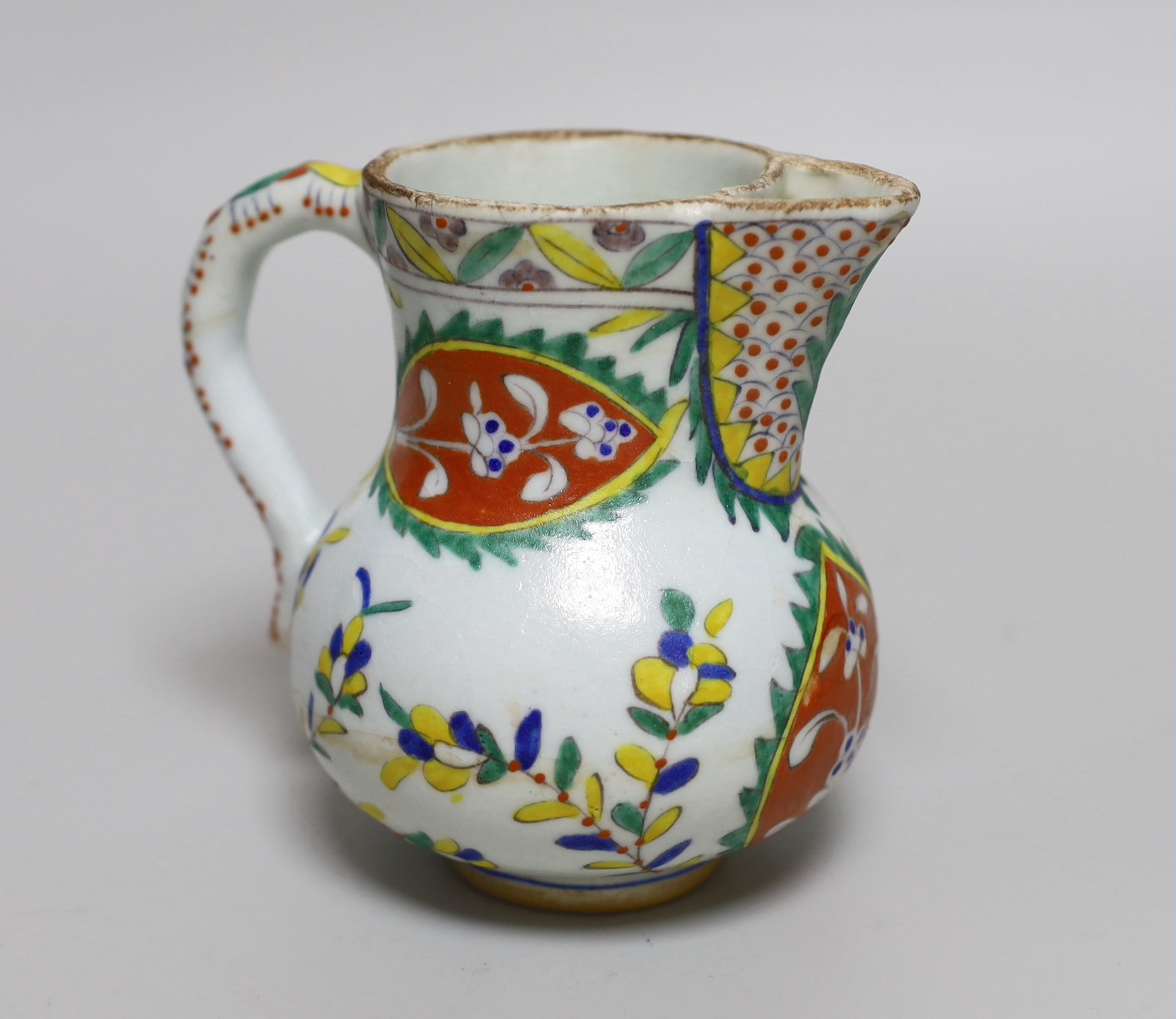 Turkish Kutahya pottery jug hand painted with stylised flowers, 12.5cm high                                                                                                                                                 