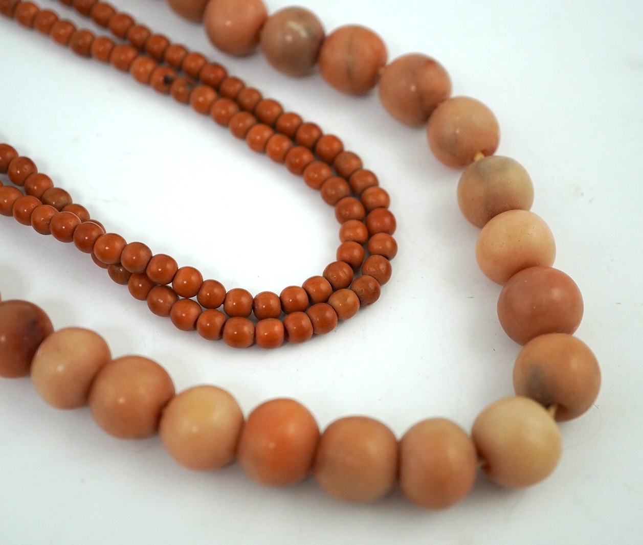 A Chinese coral bead rosary, 58cm drop and a pink soapstone bead necklace, 19.5cm. Condition - fair                                                                                                                         