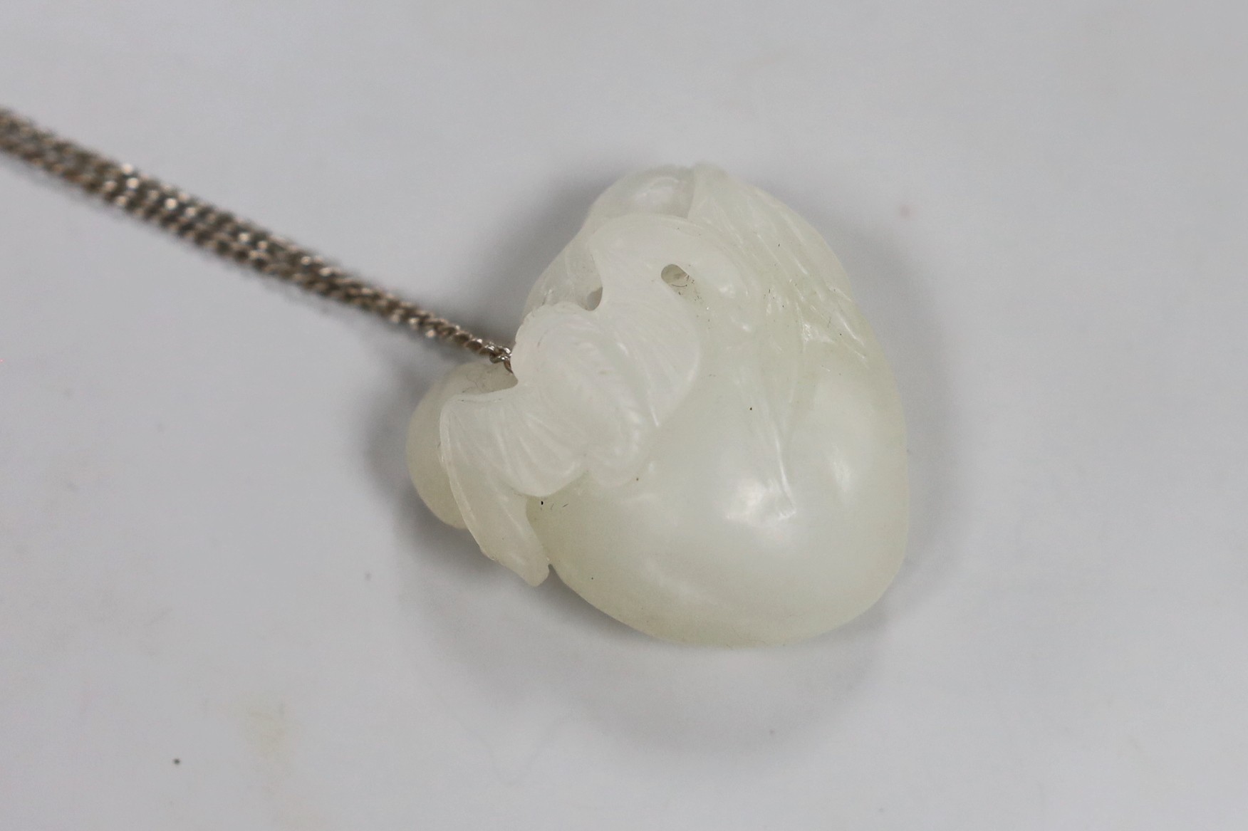 A Chinese white jade "bat and peach" pendant                                                                                                                                                                                