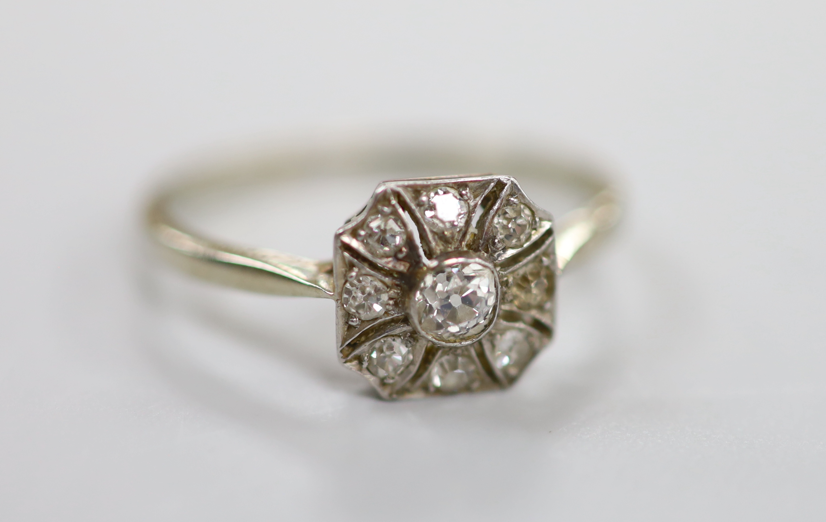 A 1920's white metal (stamped Pt) and nine stone diamond set cluster ring, size O, gross weight 2.4 grams.                                                                                                                  