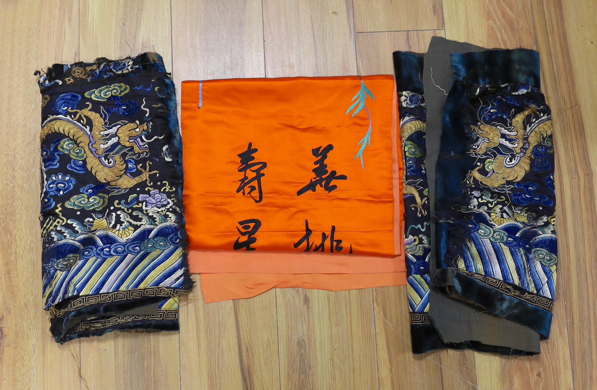 Two early 20th century Chinese silk embroidered “dragon" panels, possibly cut from an altar cloth or robe and a later inscribed banner (3)                                                                                  