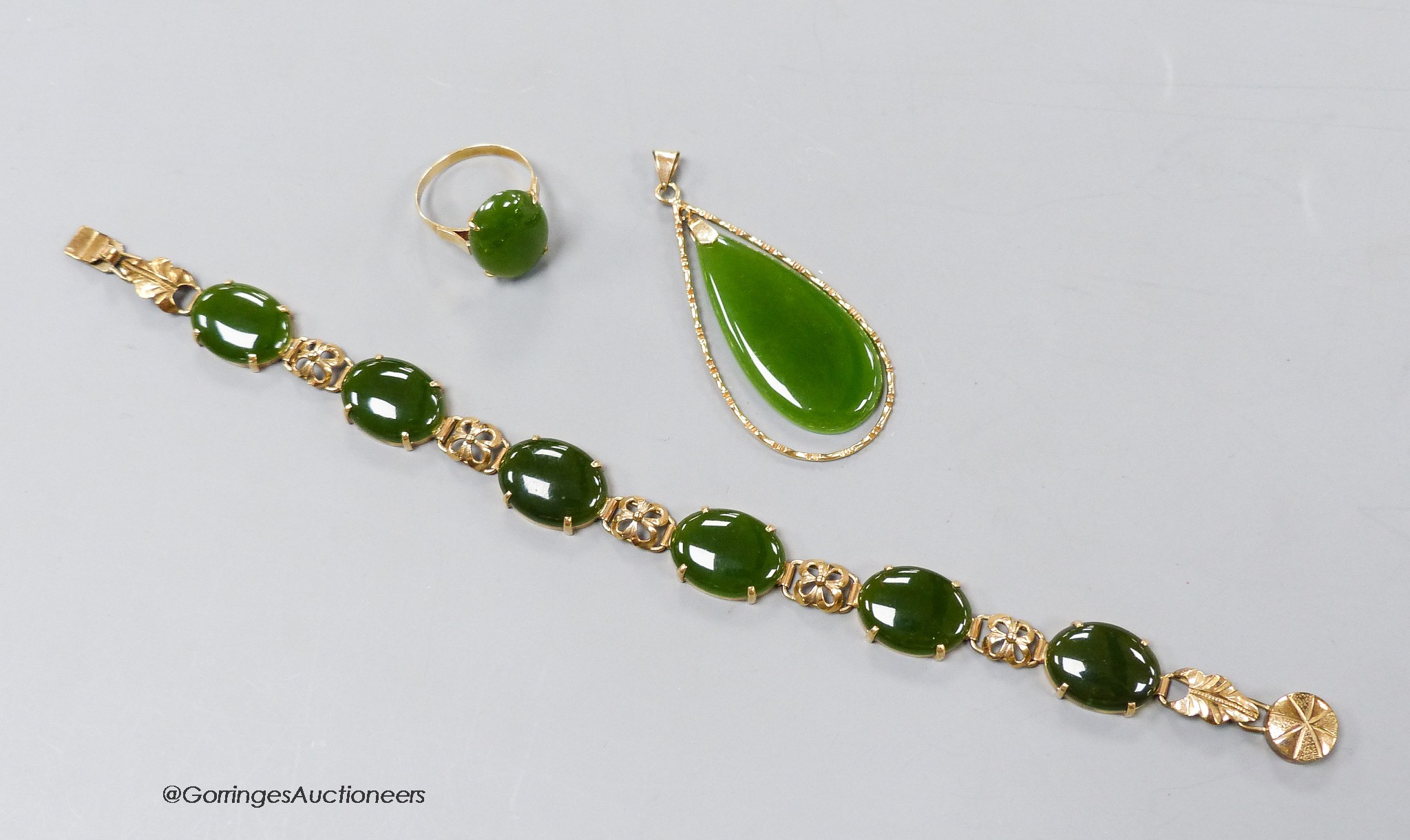 A 14k yellow metal and cabochon jade set bracelet, 18.5cm, gross 13.3 grams, an 18k mounted jade pendant and dress ring, gross 8.5 grams.                                                                                   