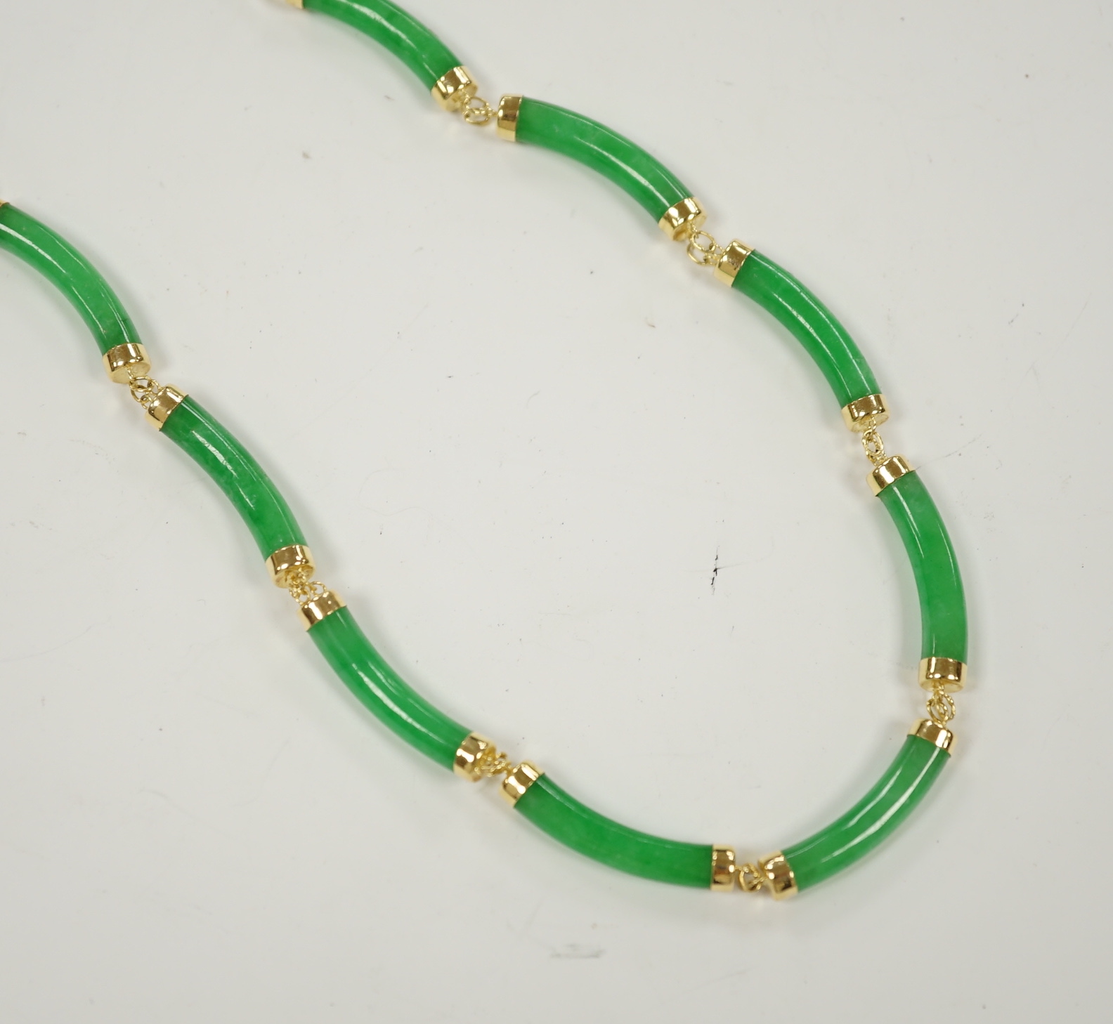 A 14k yellow metal and curved jade link necklace, 42cm, gross weight 25 grams.                                                                                                                                              