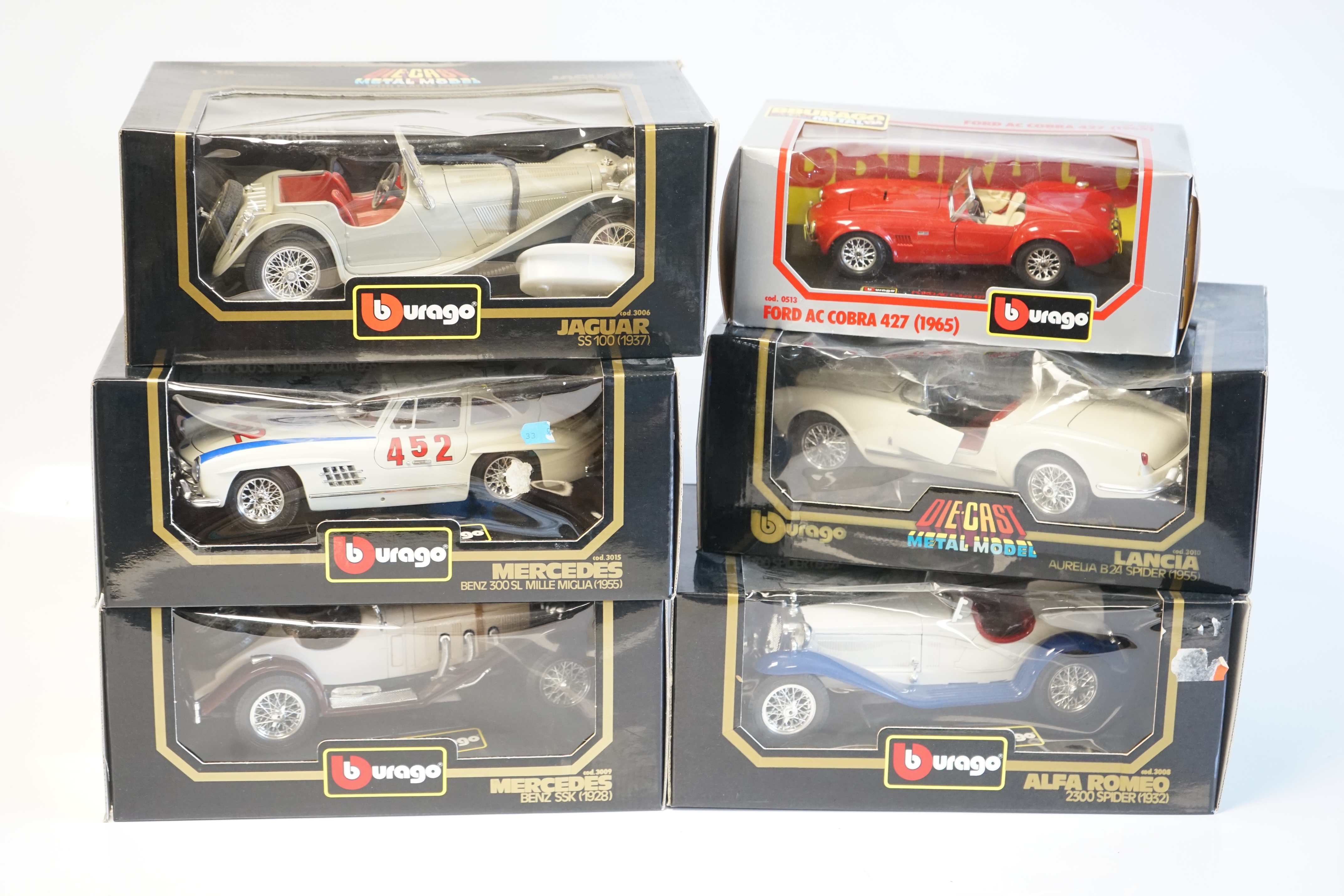 Six boxed Burago Diecast racing cars, five in 1/18 scale including; a Mercedes-Benz SSK, a Mercedes-Benz 300SL, a Jaguar SS100, a Lancia Aurelia B24 spider and an Alfa Romeo 2300 spider, together with a 1/24 scale Ford A