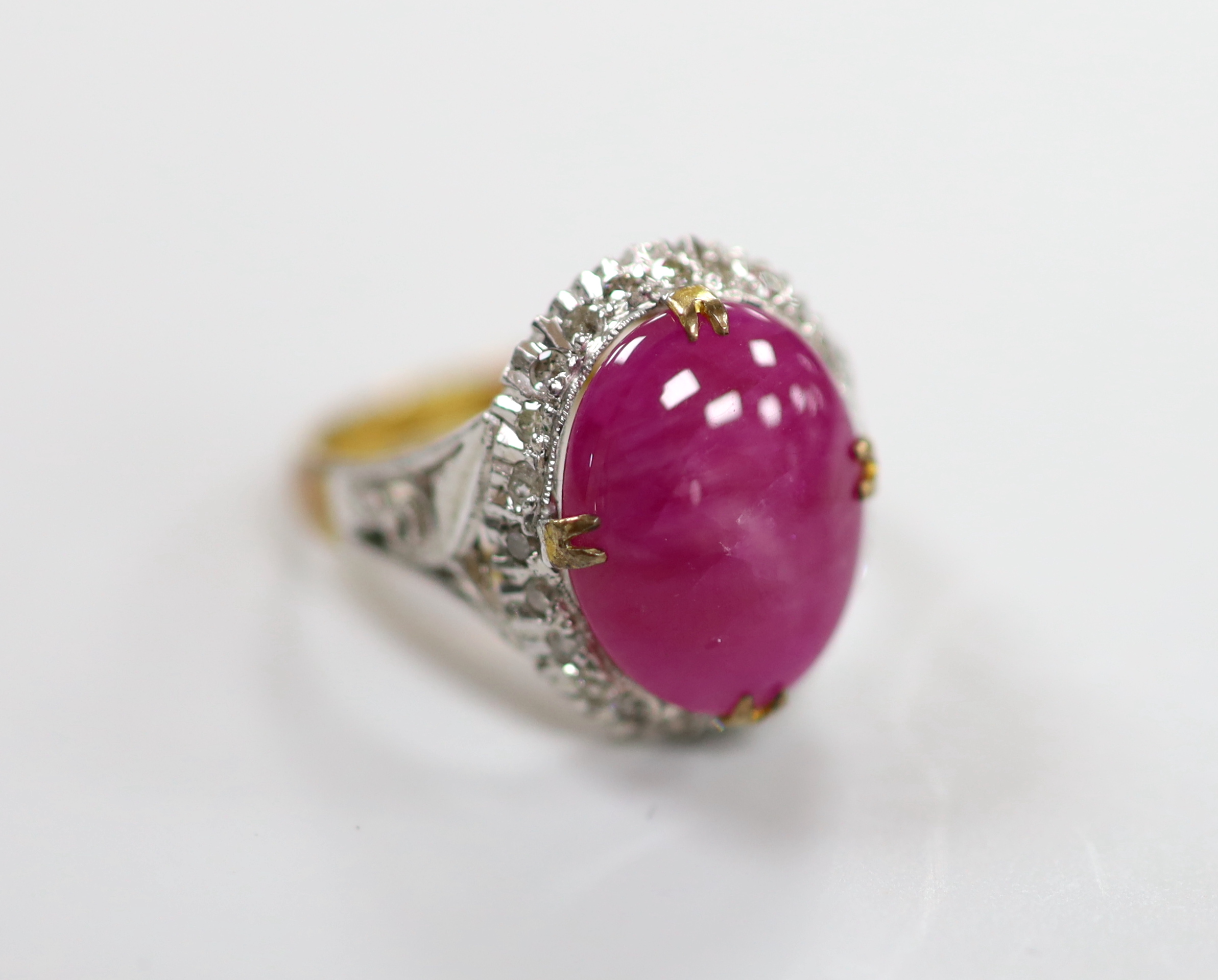 A yellow metal cabochon ruby and diamond chip set oval cluster ring, size M/N, gross weight 4.9 grams.                                                                                                                      