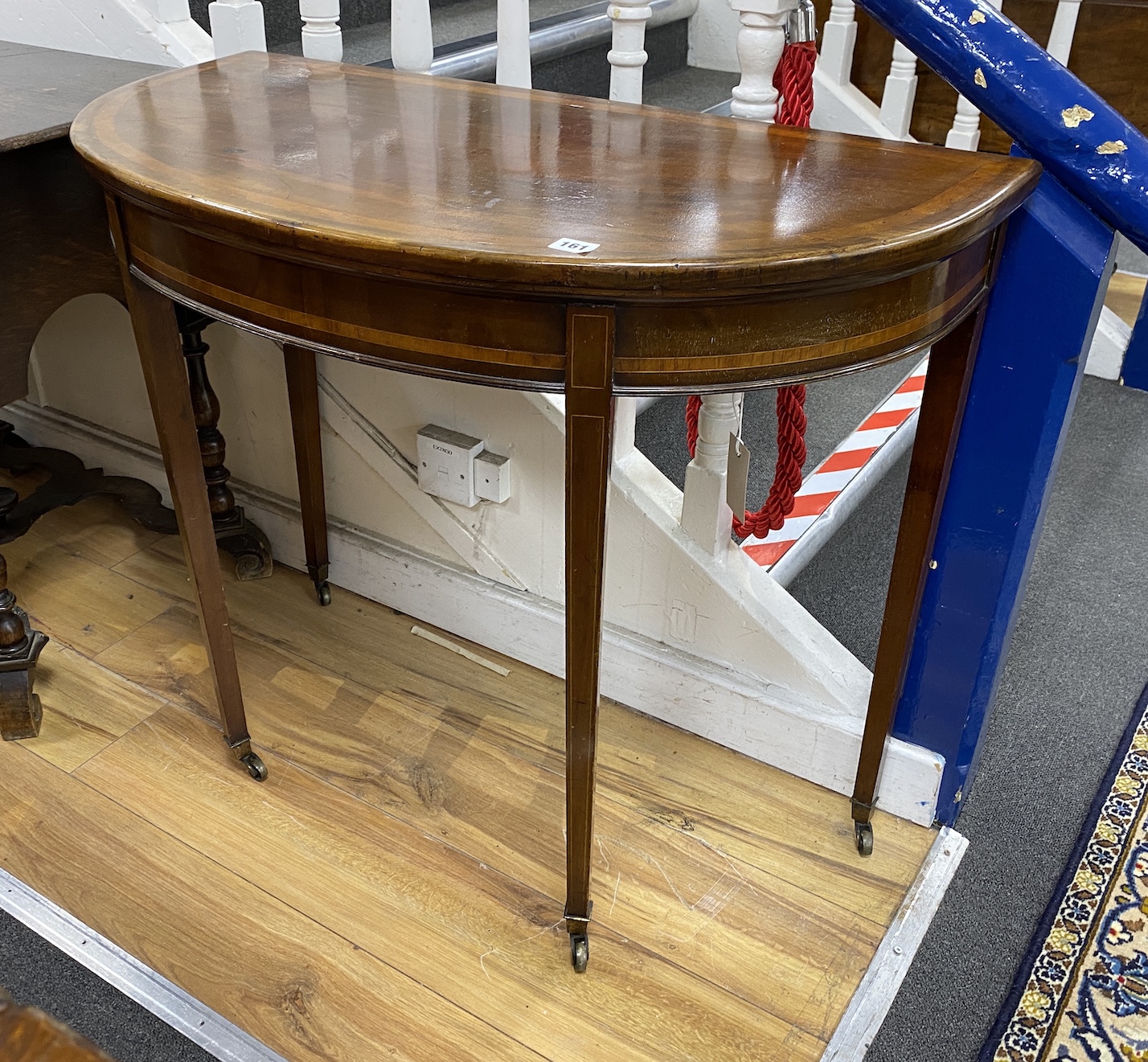 A George III satinwood banded mahogany 'D' shape folding card table                                                                                                                                                         