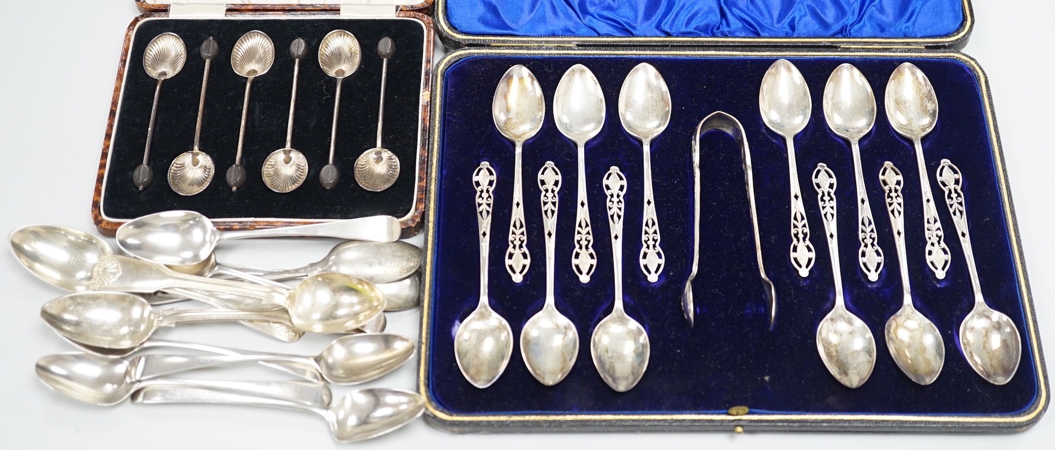 A cased set of twelve George V pierced silver teaspoons, with tongs, Sheffield, 1910, one other cased set of six silver bean end coffee spoons and eleven assorted mainly 19th century silver teaspoons.                    