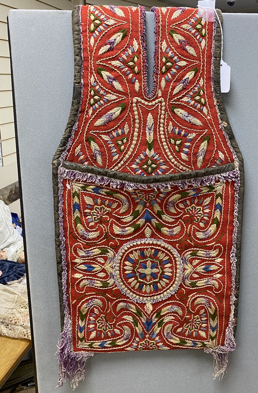 An early 20th century Turkish red wool ground saddlebag, embroidered with multicoloured wools and bound with leather, 37cm wide, 130cm long                                                                                 