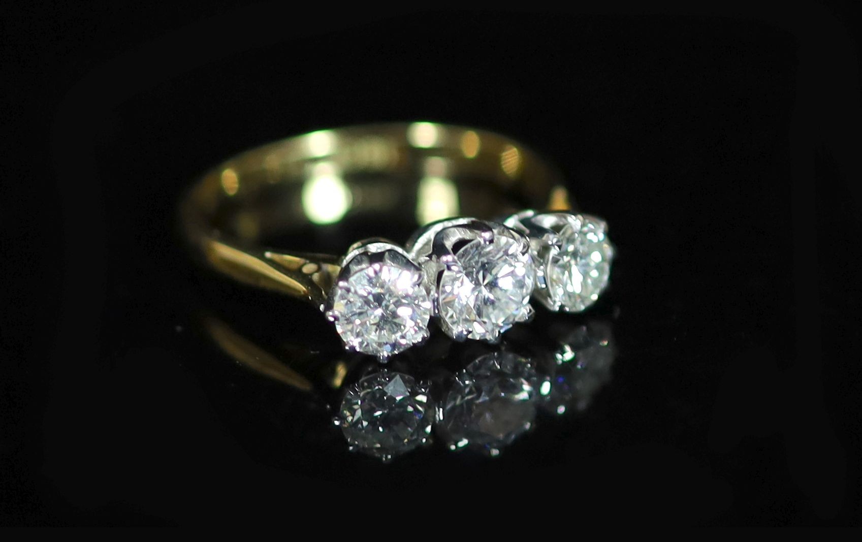 A 18ct gold and platinum, three stone diamond ring                                                                                                                                                                          