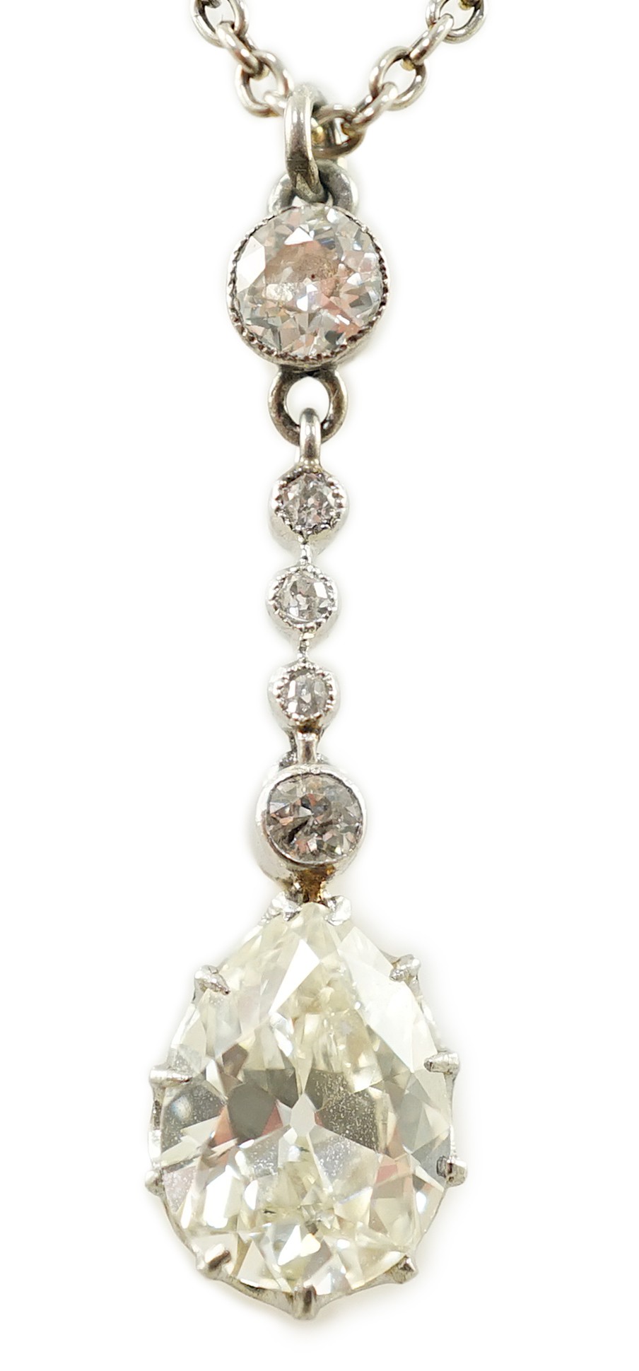 An early to mid 20th century white and yellow gold, six stone diamond set drop pendant, on a white gold chain, the clasp stamped 9k                                                                                         